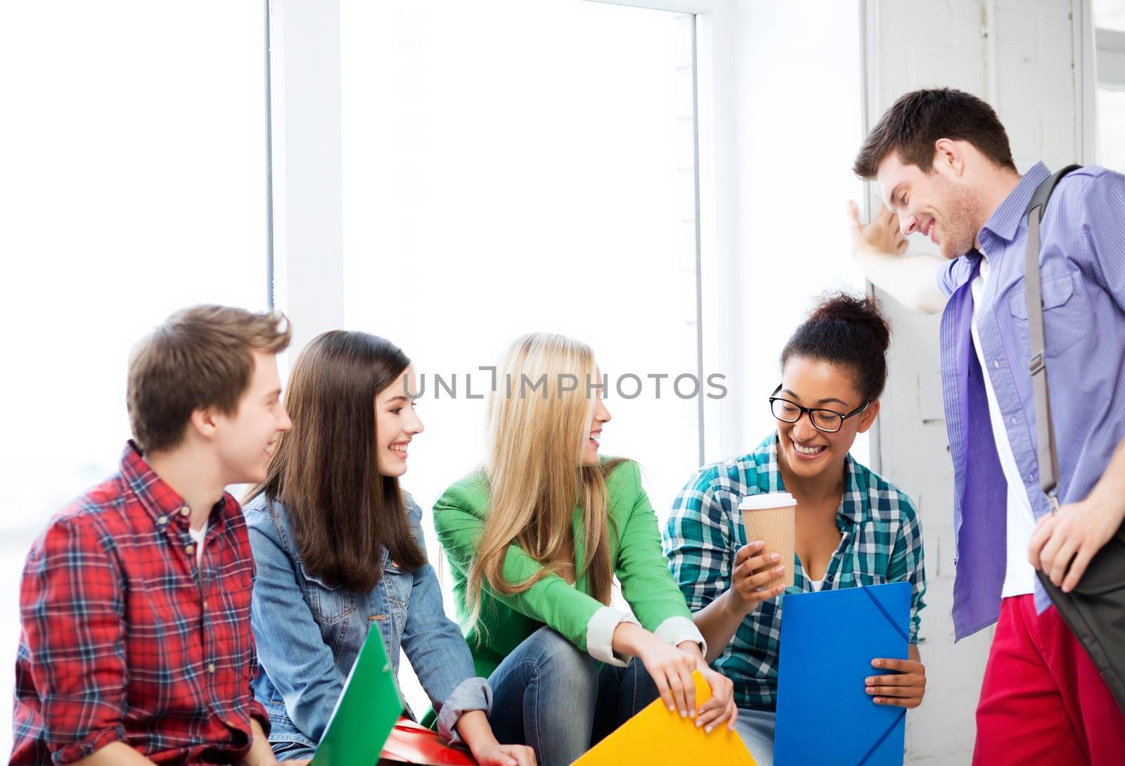 education concept - students communicating and laughing at school