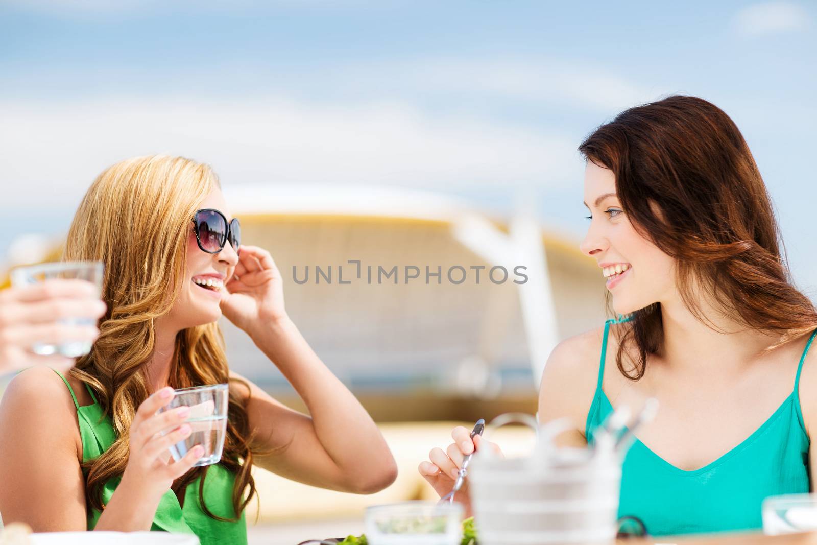 girls in cafe on the beach by dolgachov