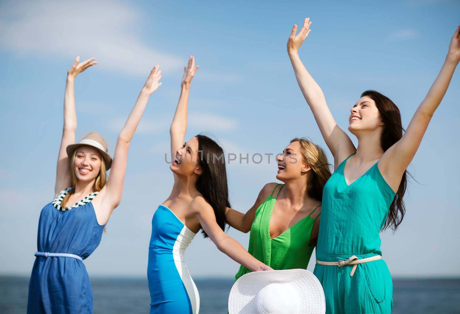 girls looking at the sea with hands up by dolgachov