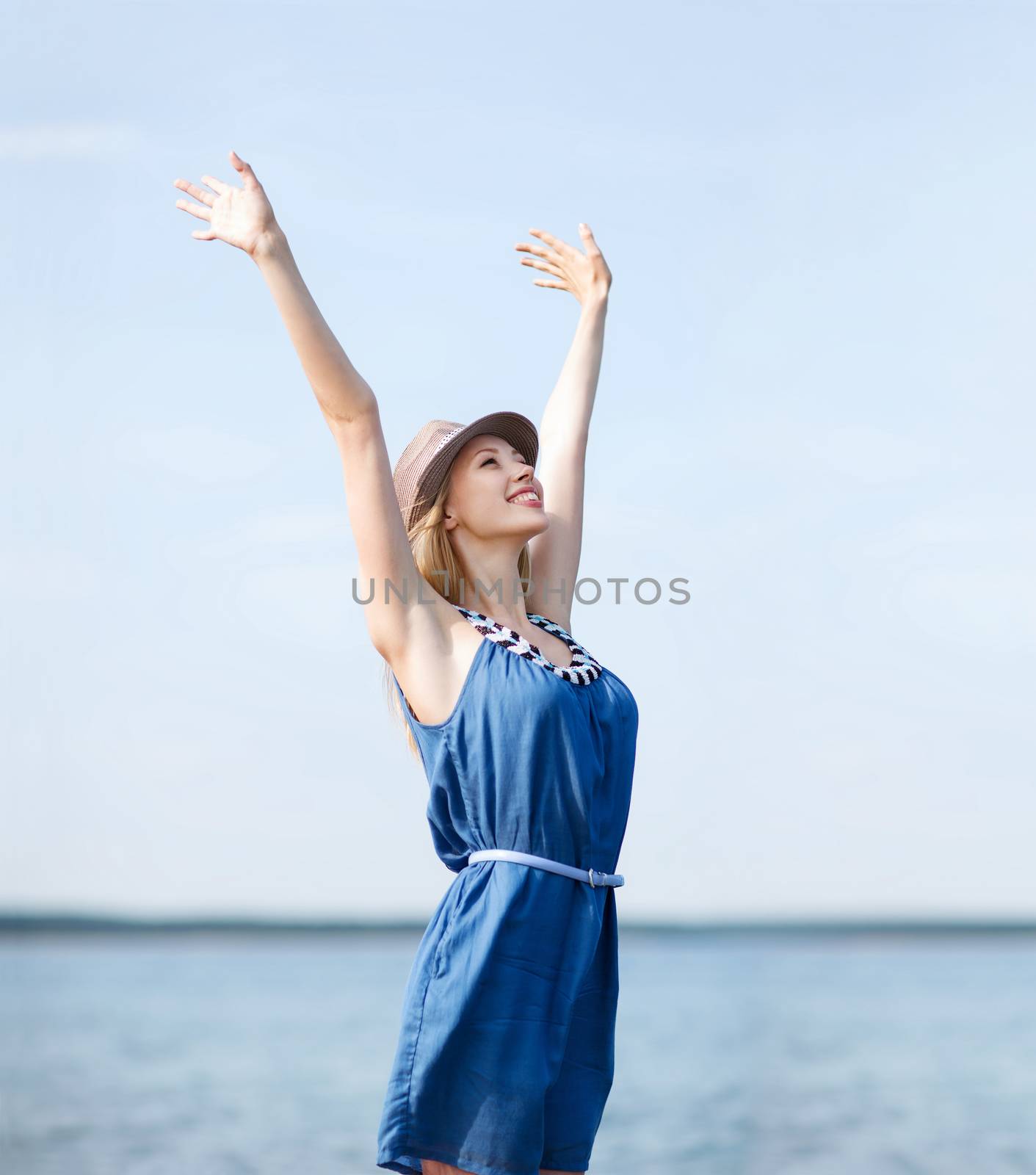 girl with hands up on the beach by dolgachov