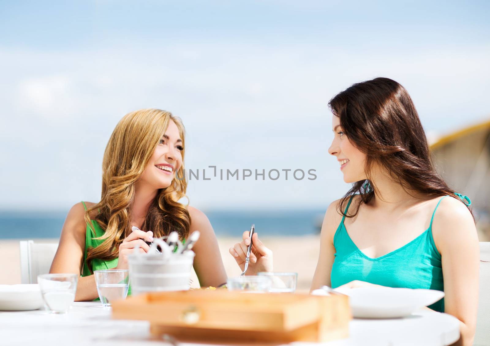 girls in cafe on the beach by dolgachov