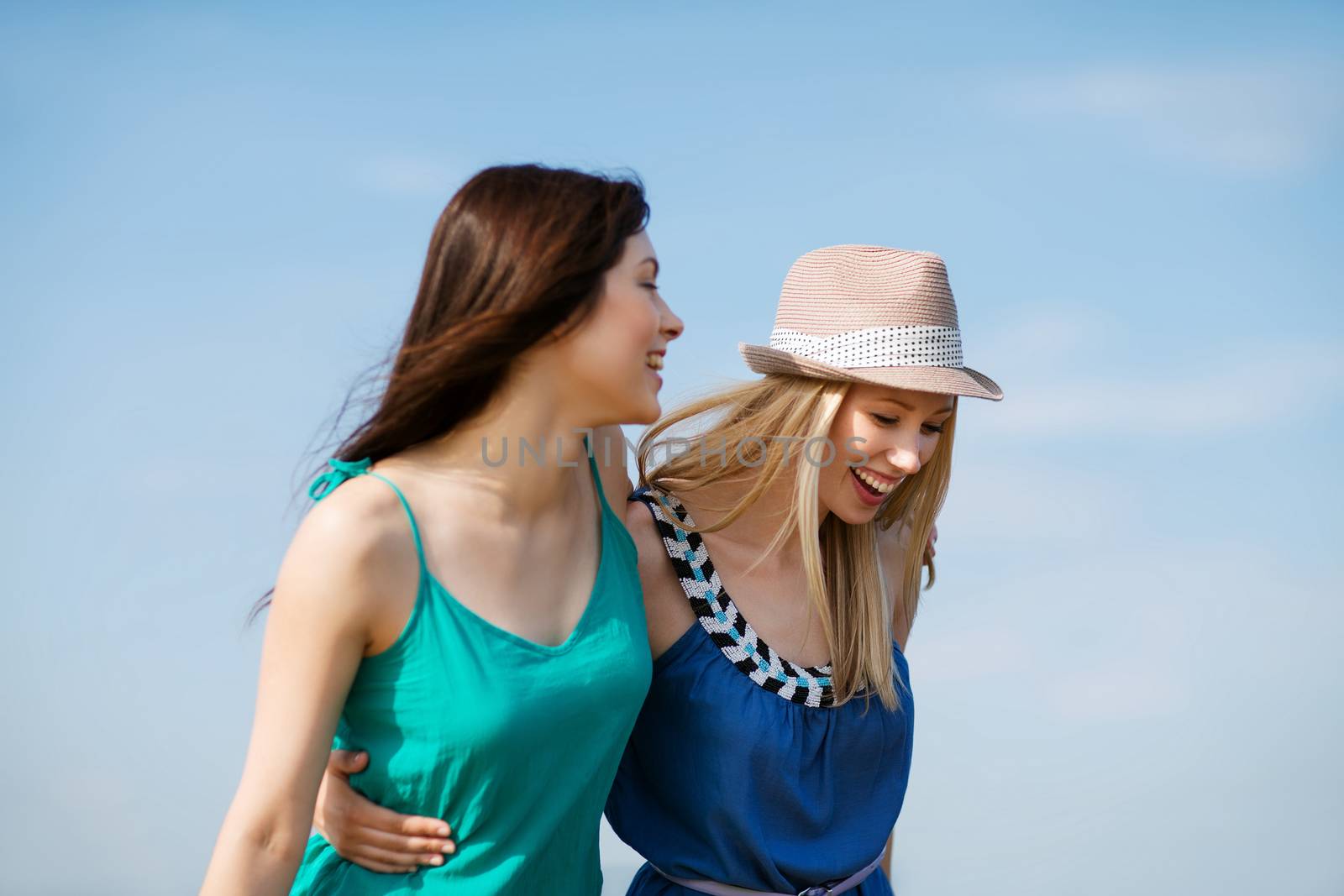 summer holidays and vacation - girls walking on the beach