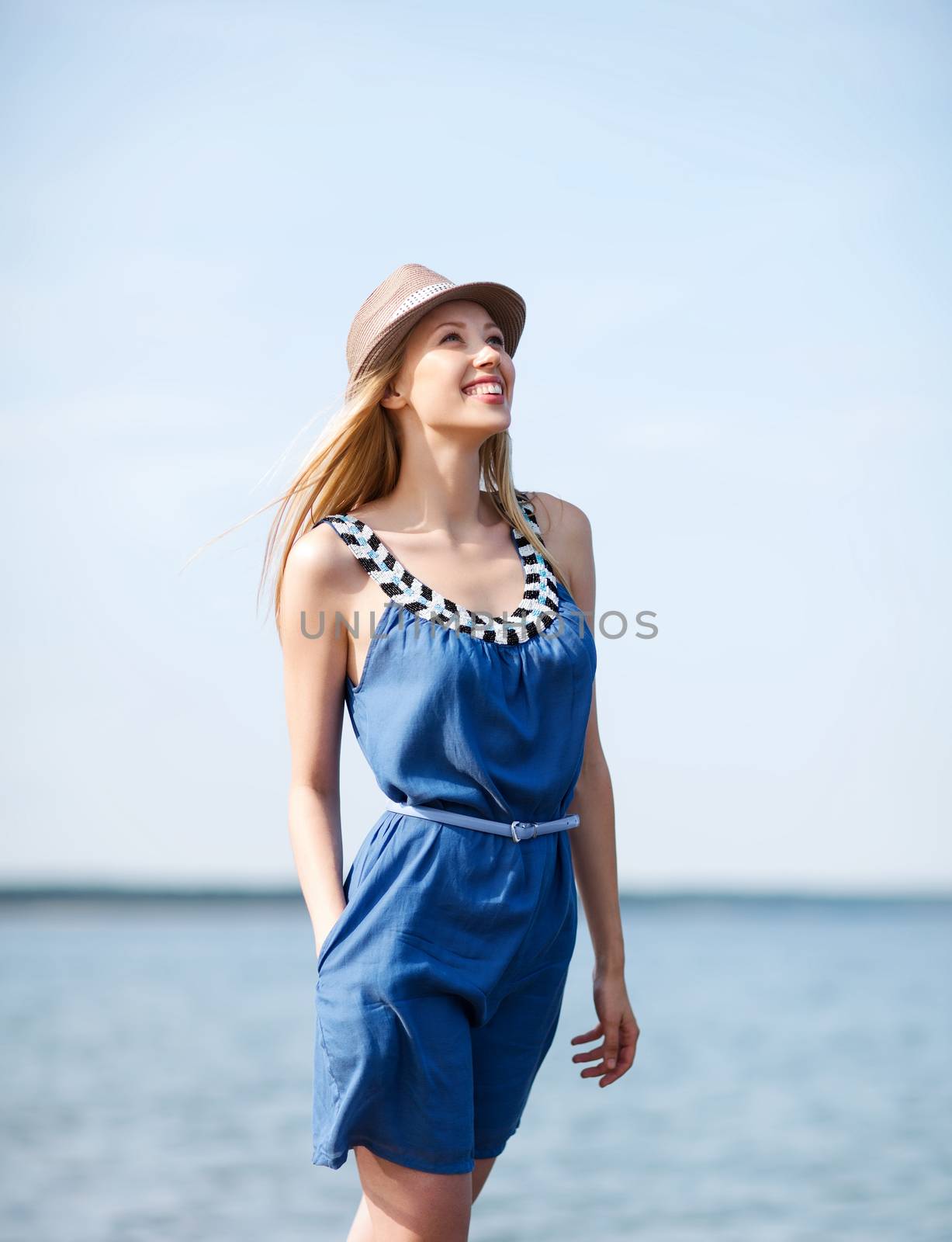 summer holidays and vacation - girl in hat walking on the beach