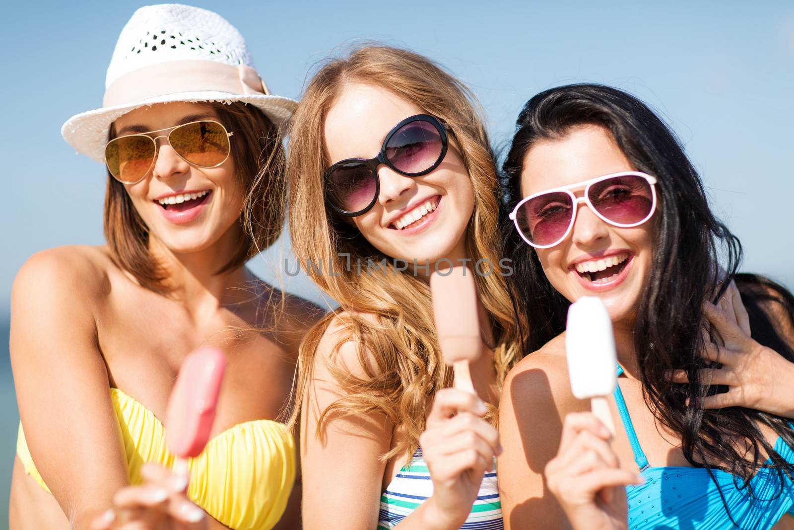 girls in bikinis with ice cream on the beach by dolgachov