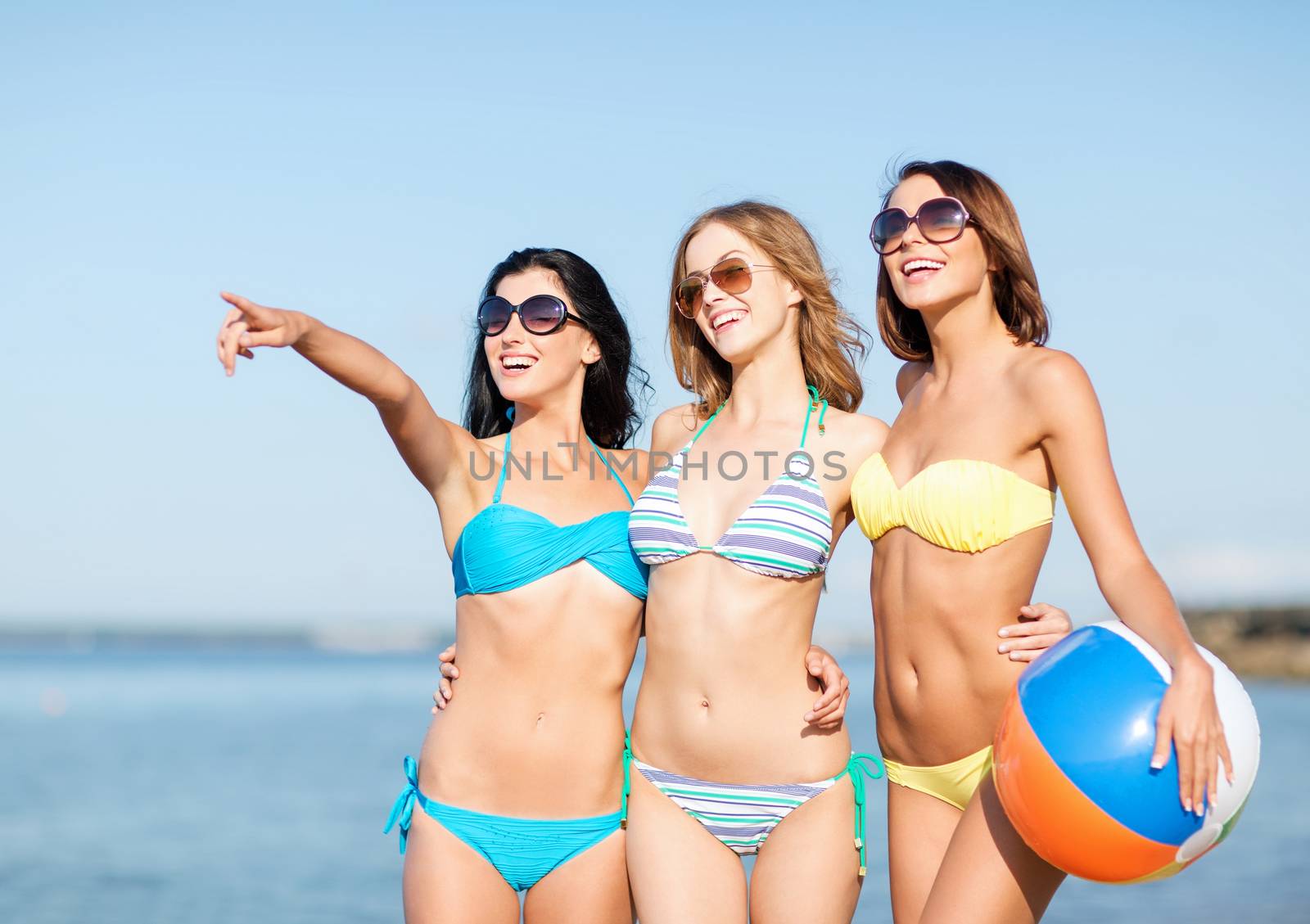 summer holidays, vacation and beach activities - girls in bikinis with ball on the beach