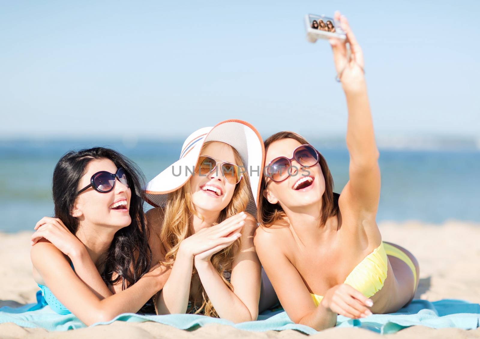 girls taking self photo on the beach by dolgachov