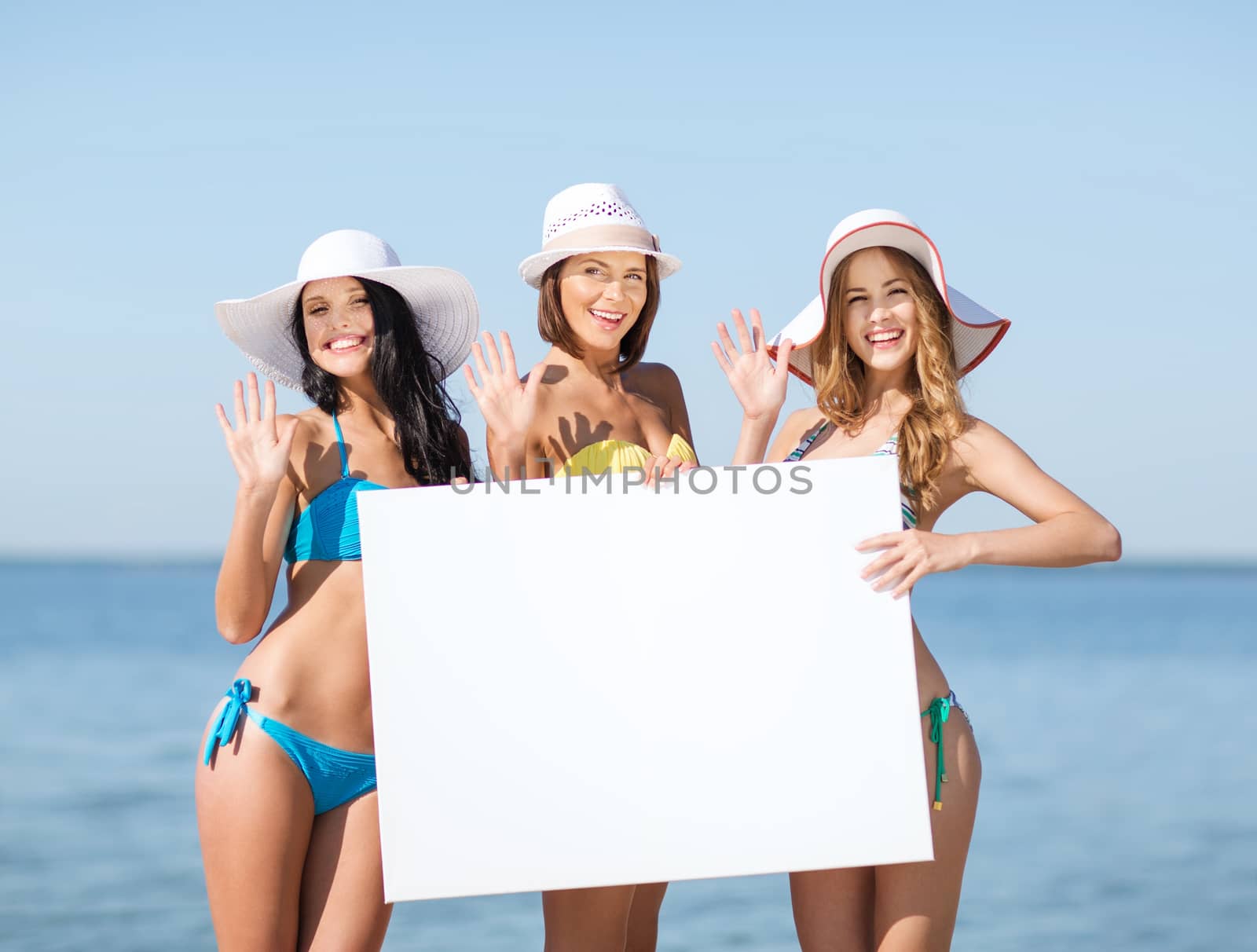 girls with blank board on the beach by dolgachov