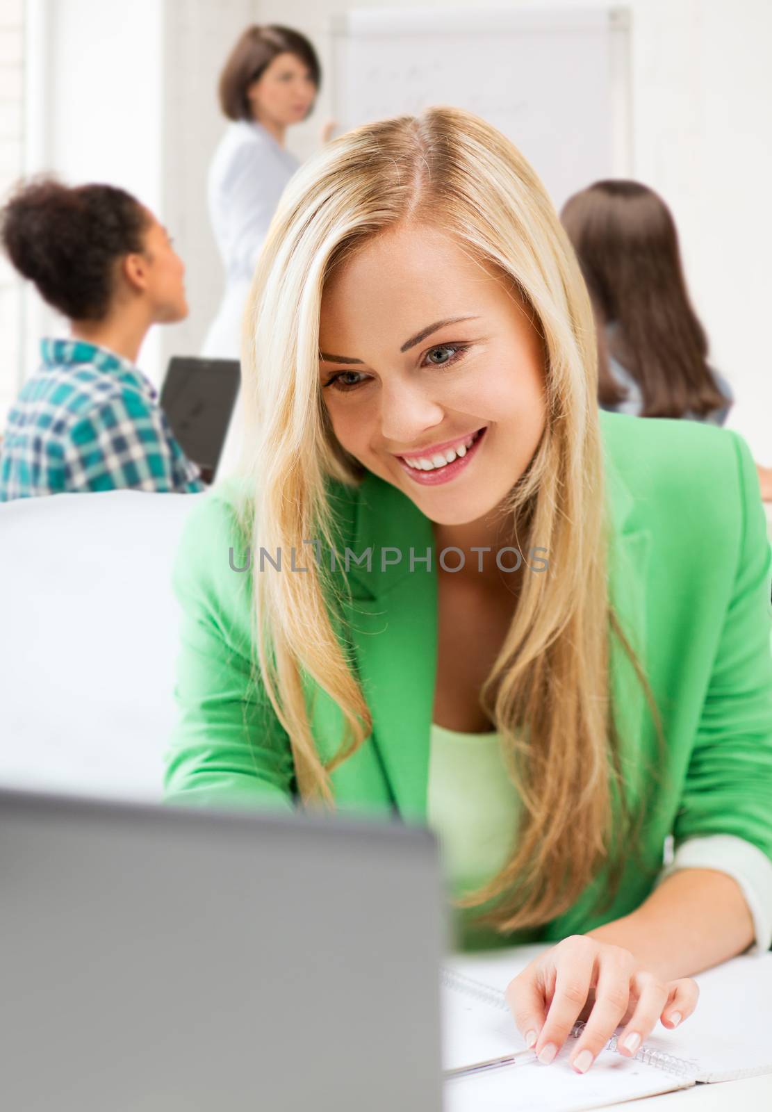 education and internet concept - student girl with laptop in college