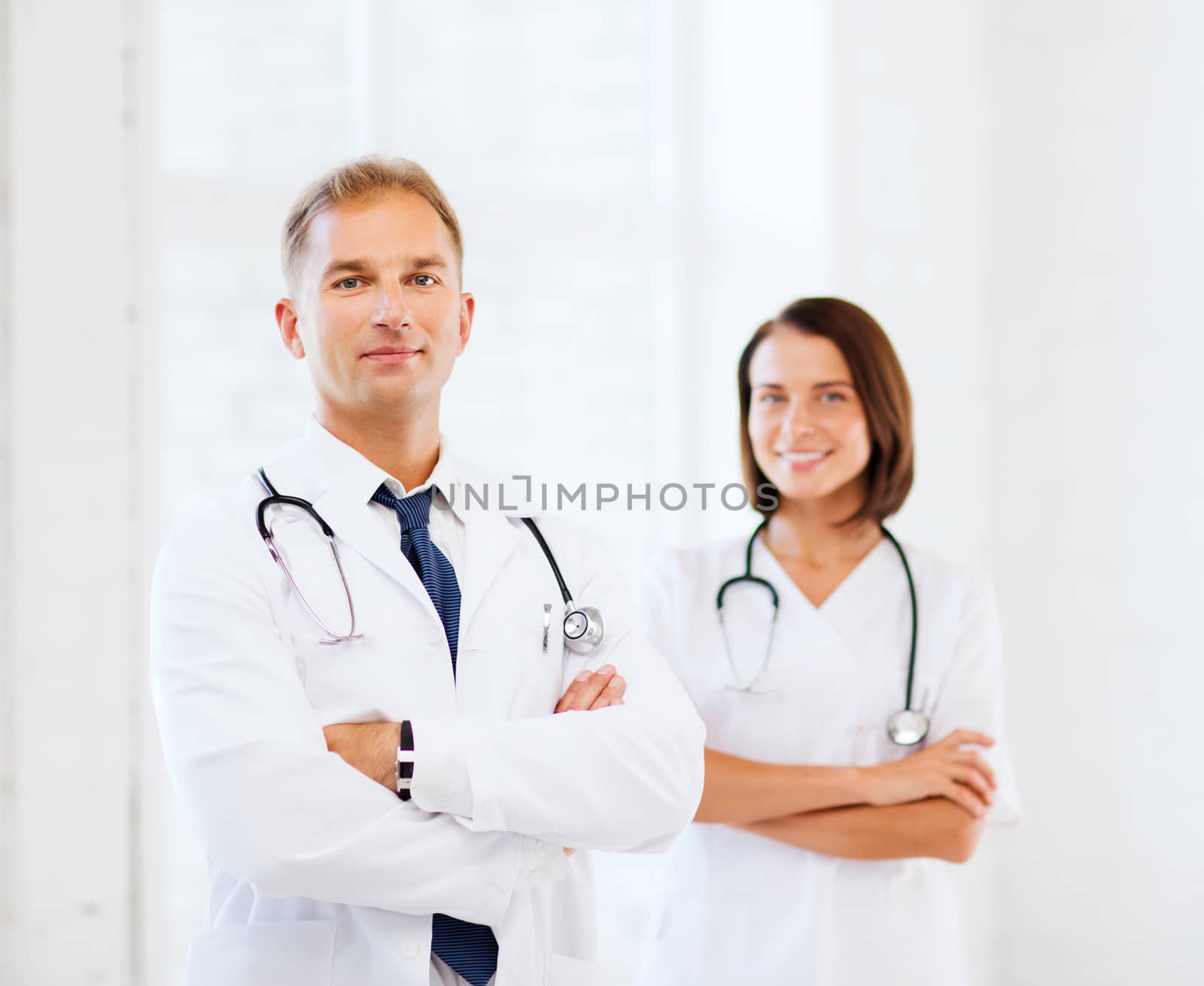 healthcare and medical concept - two doctors with stethoscopes