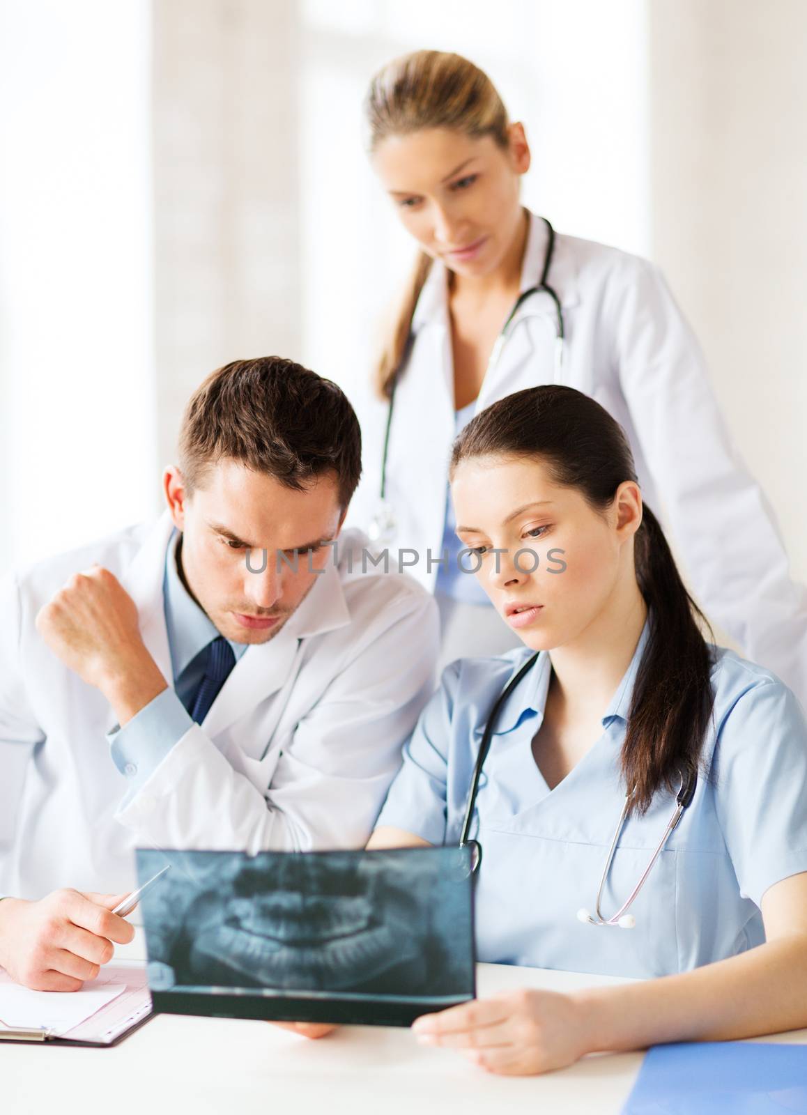 healthcare, medical and radiology concept - group of doctors looking at x-ray