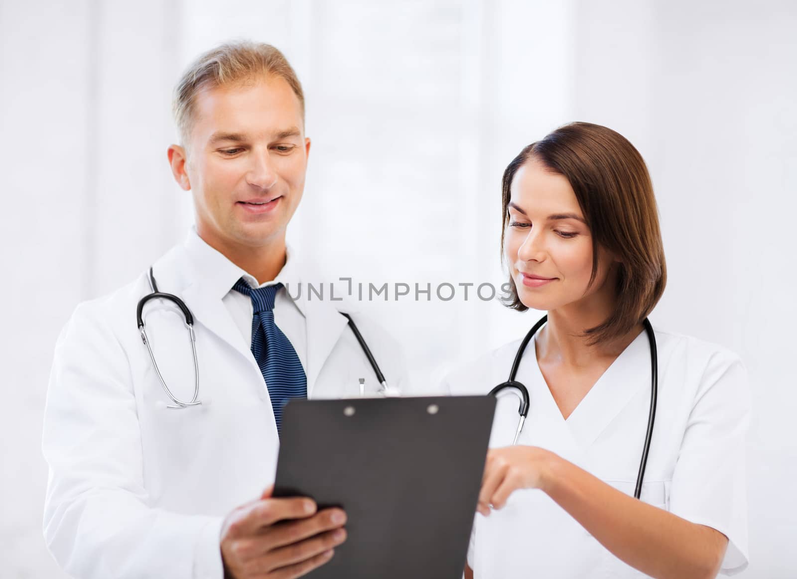 healthcare and medical concept - two doctors discussing diagnosis