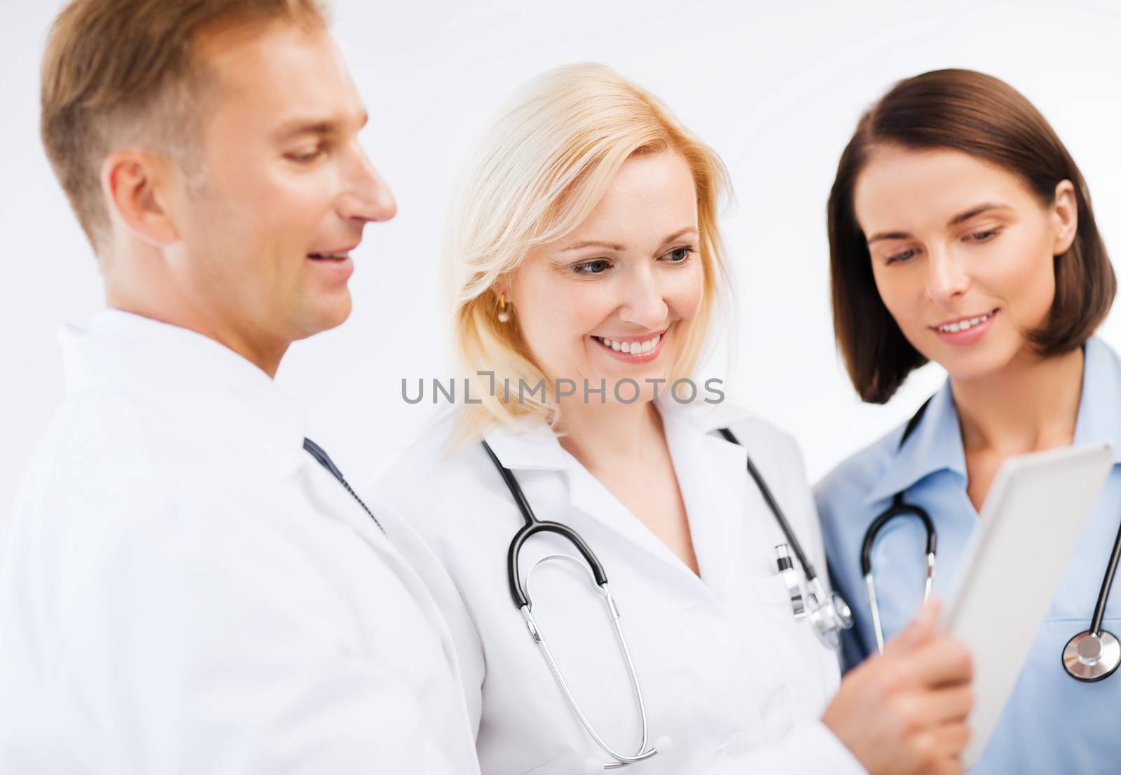 doctors looking at tablet pc by dolgachov