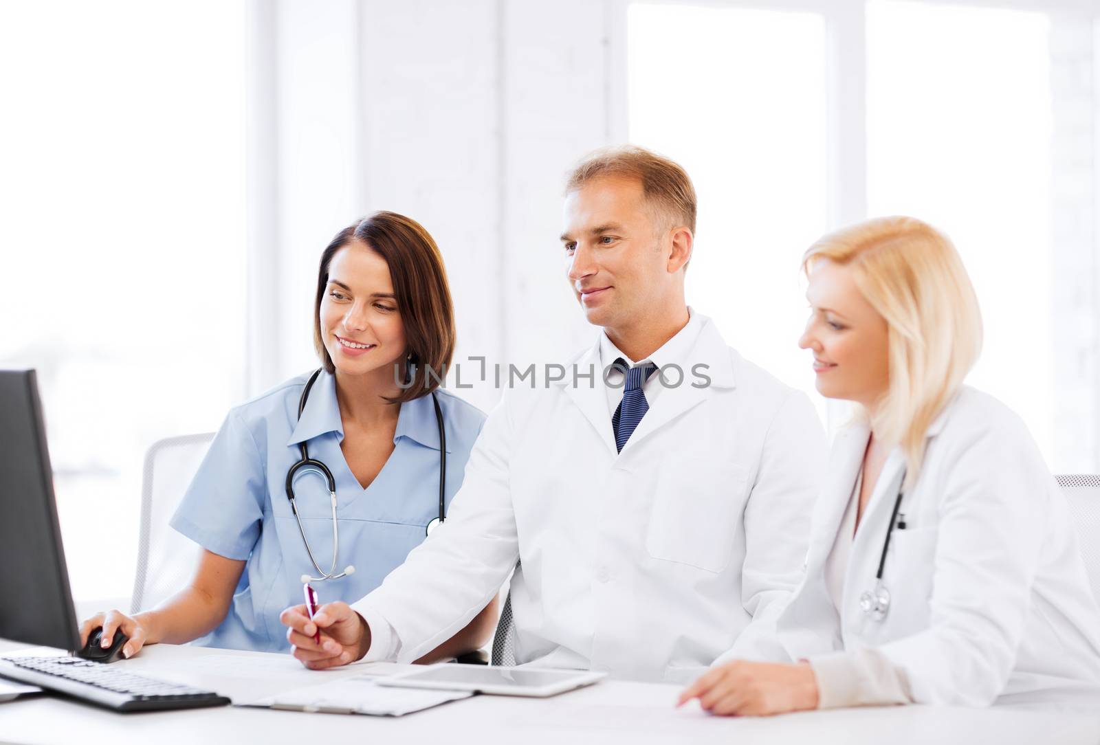 doctors looking at computer on meeting by dolgachov