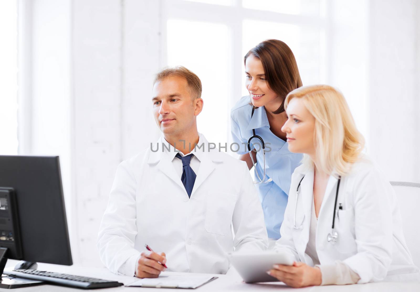 healthcare, medical and technology - group of doctors looking at computer on meeting