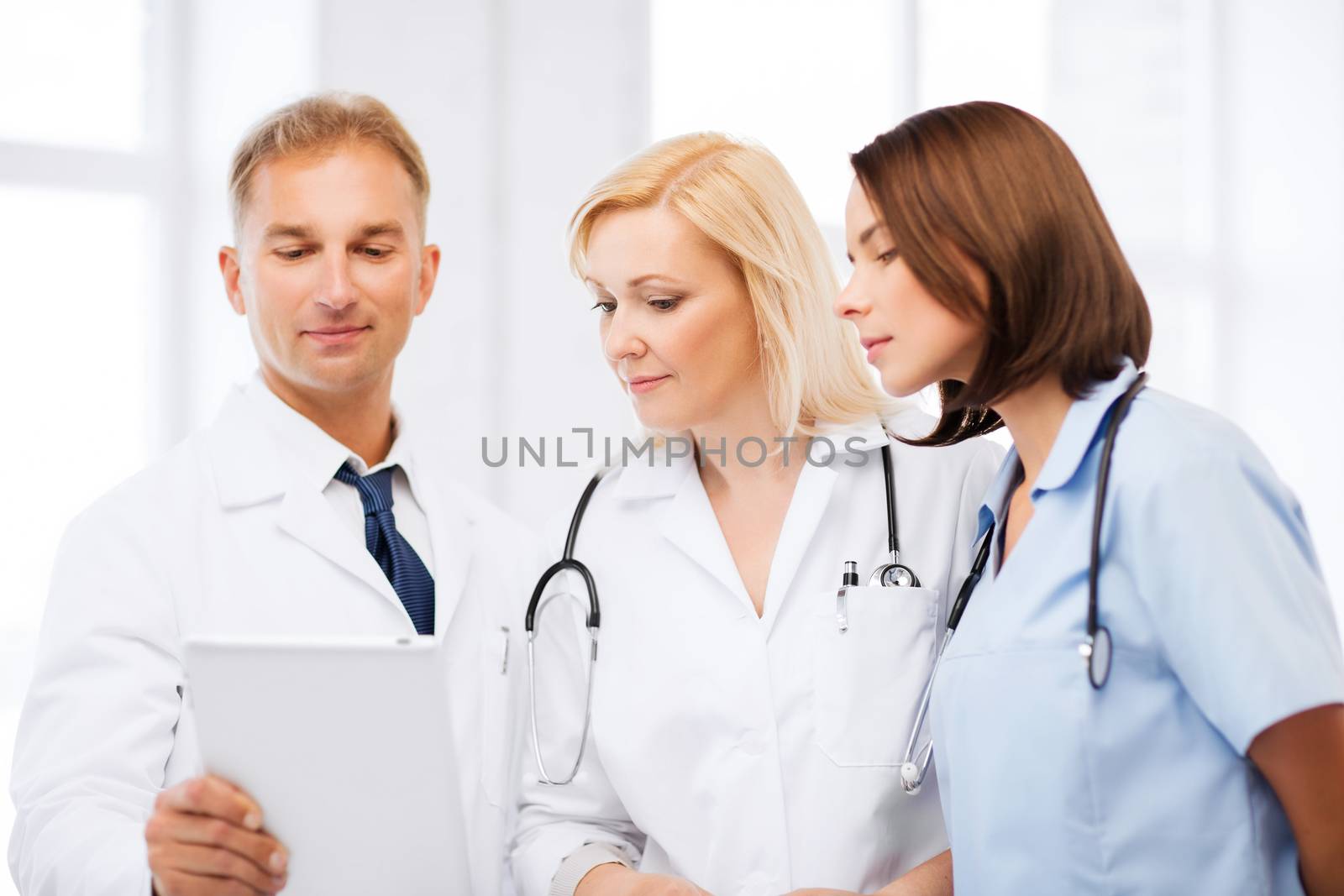 healthcare and technology concept - doctors looking at tablet pc