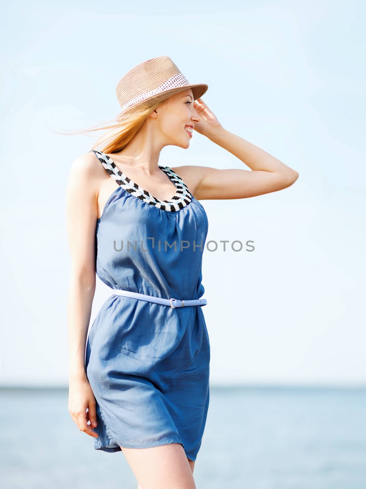 girl in hat walking on the beach by dolgachov