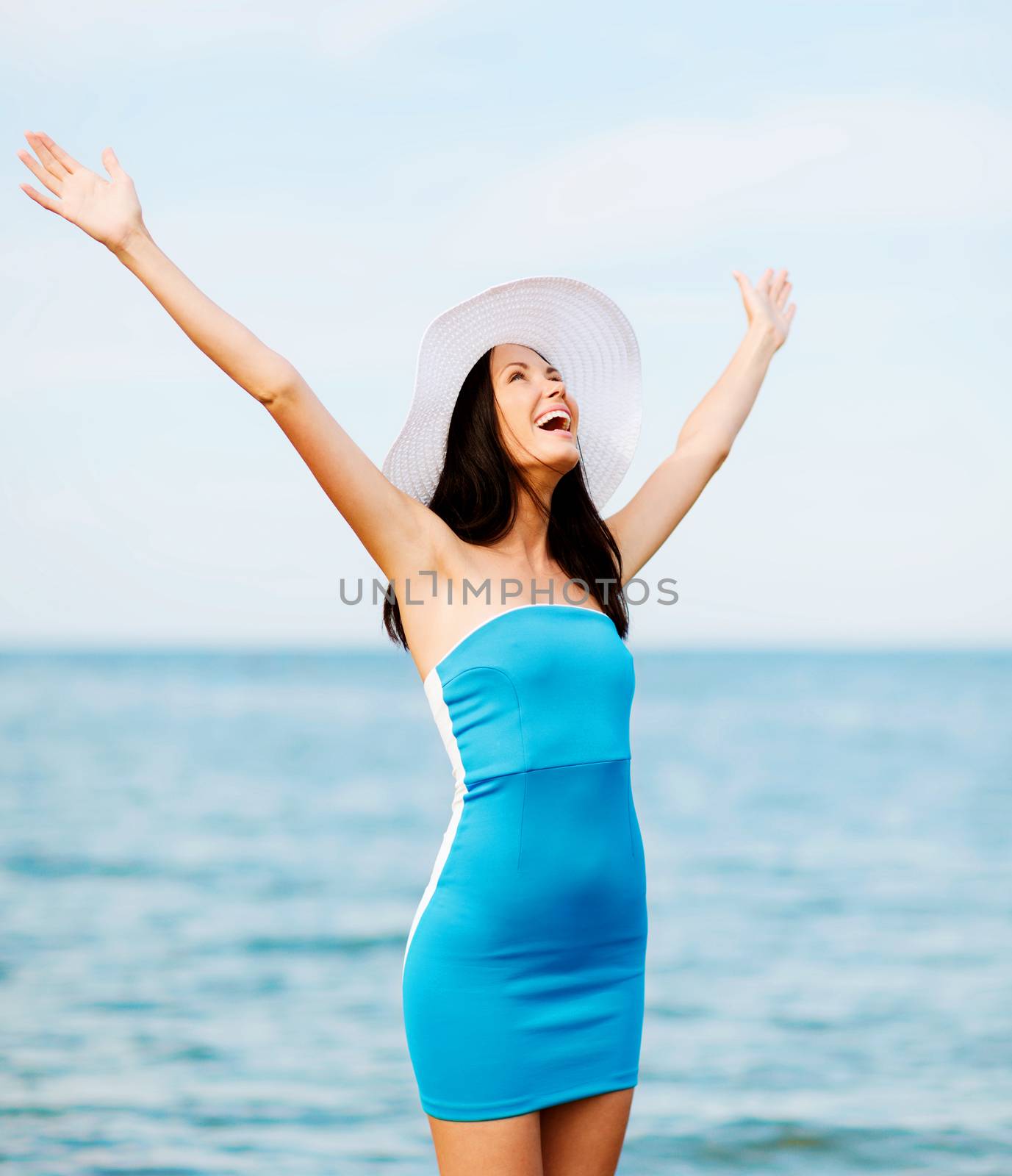 summer holidays and vacation - girl with hands up on the beach