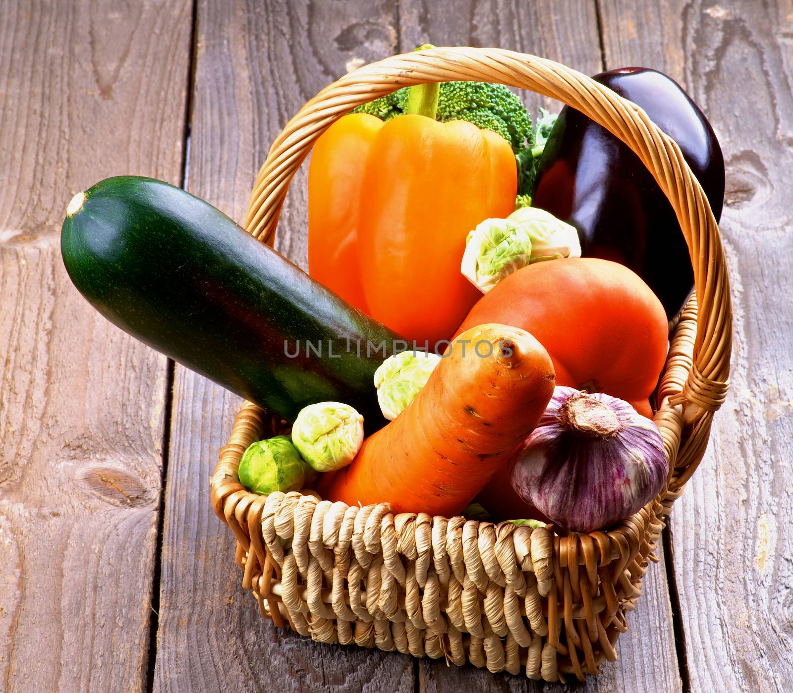 Various Colorful Ripe Raw Vegetables in Wicker Basket closeup on Rustic Wooden background