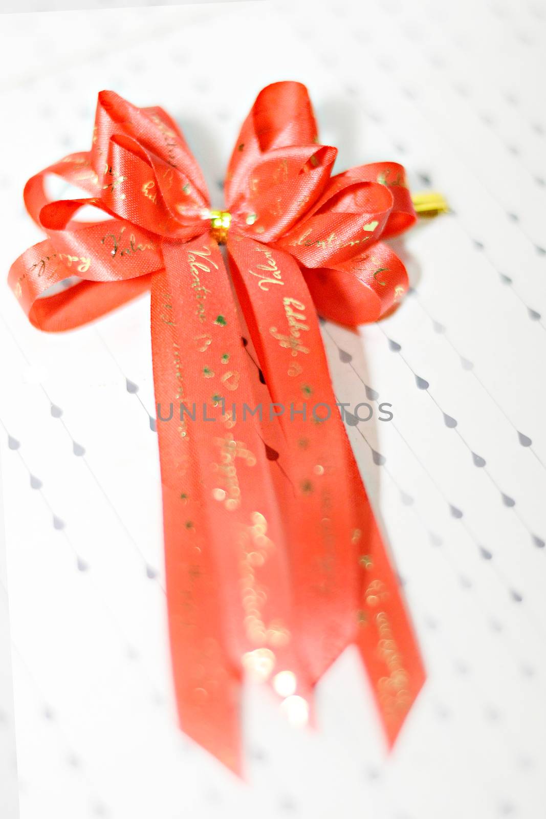 Decoration red glossy ribbon bow on ribbon print word valentine by Yuri2012