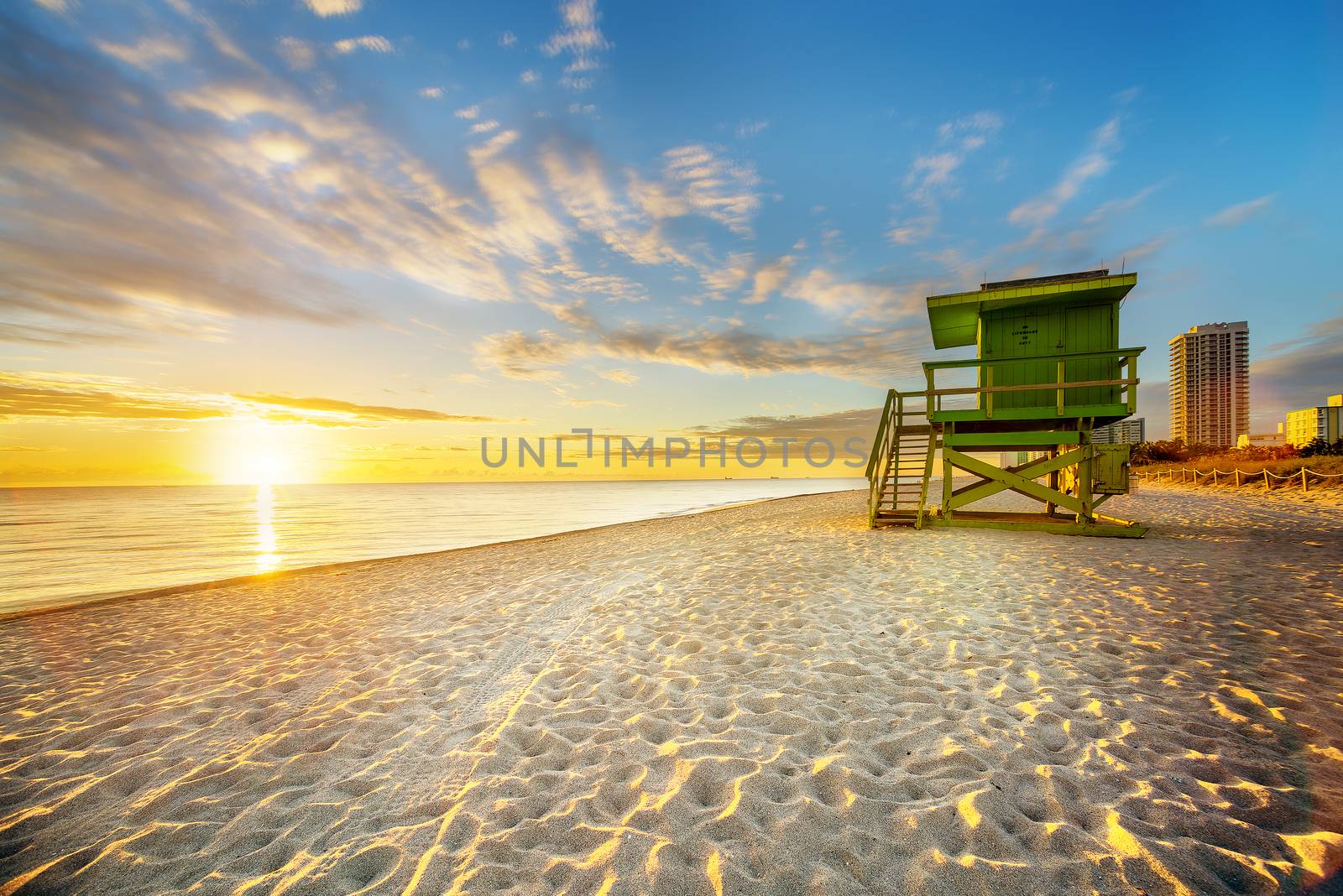 Miami South Beach sunrise with lifeguard tower and coastline with colorful cloud and blue sky. 