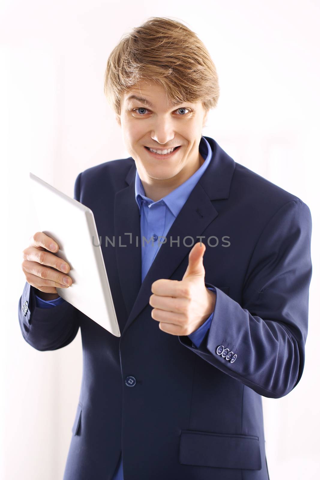 Portrait of a young elegant man in blue suit holding a digital tablet