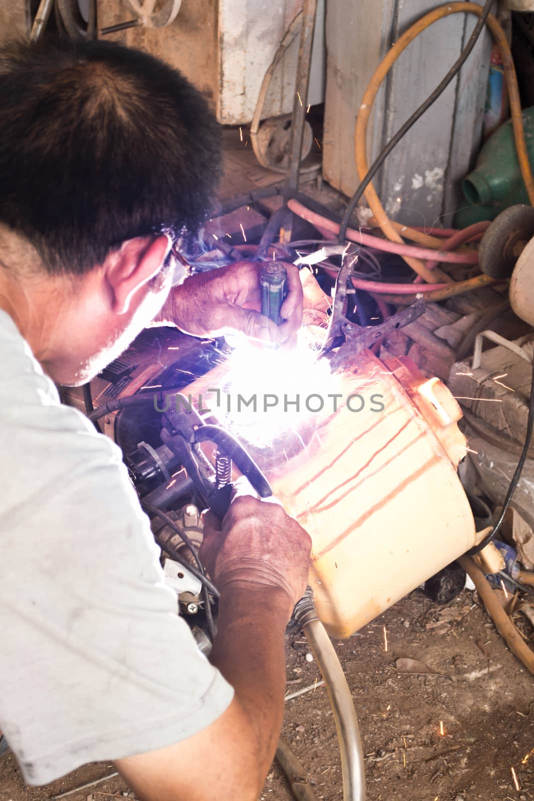 Welder working a welding metal and sparks  by Thanamat