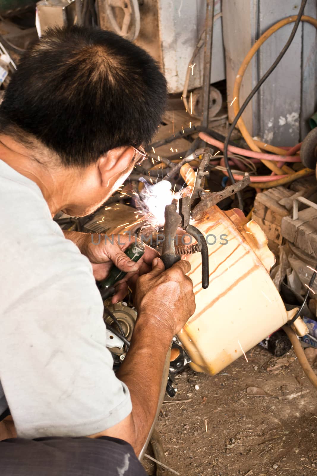 Welder working a welding metal and sparks by Thanamat