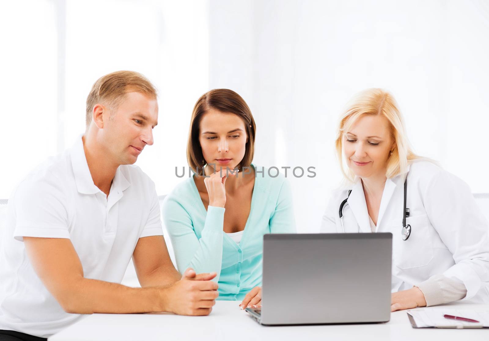 healthcare, medical and technology concept - doctor with patients looking at laptop