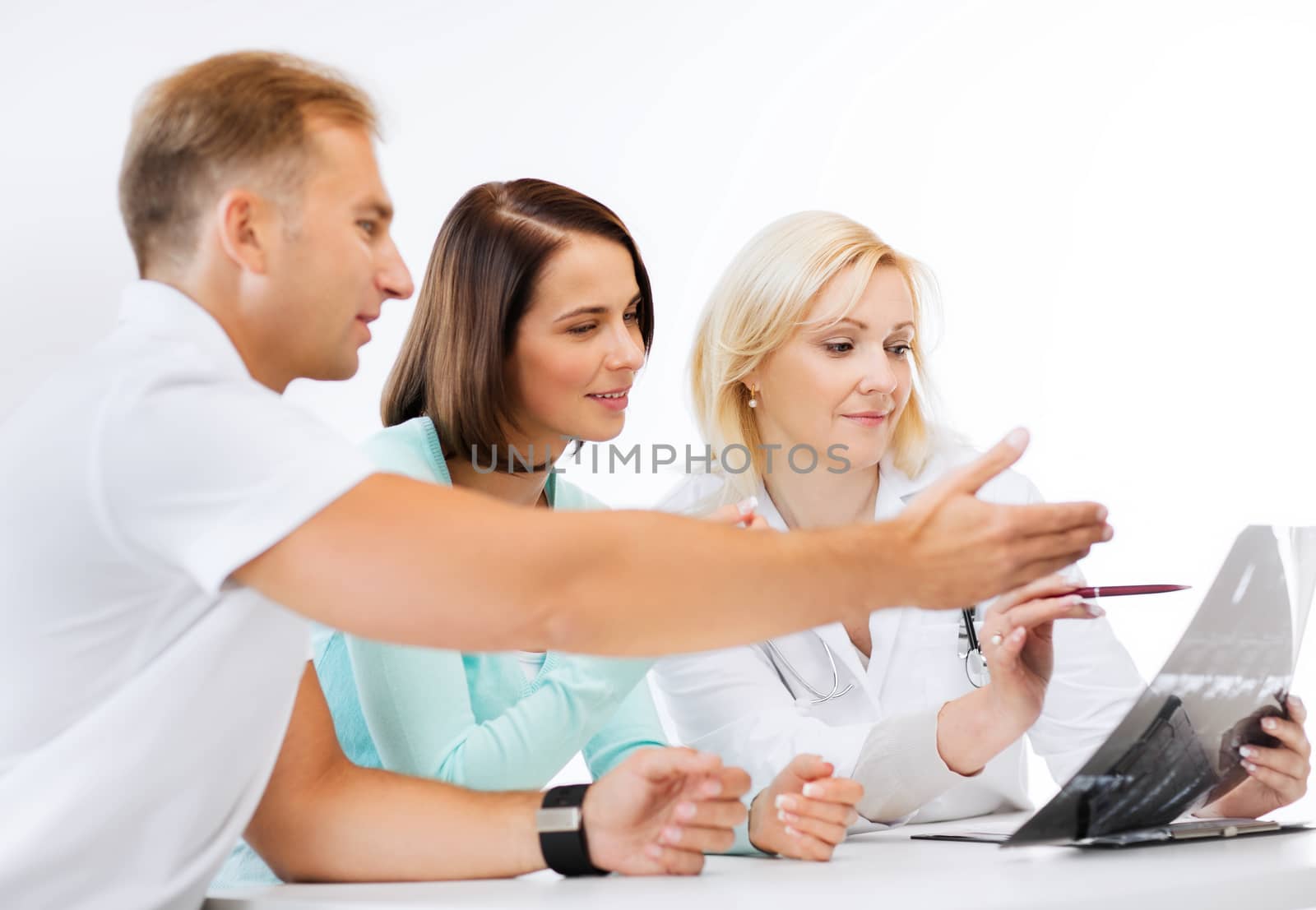 doctor with patients looking at x-ray by dolgachov