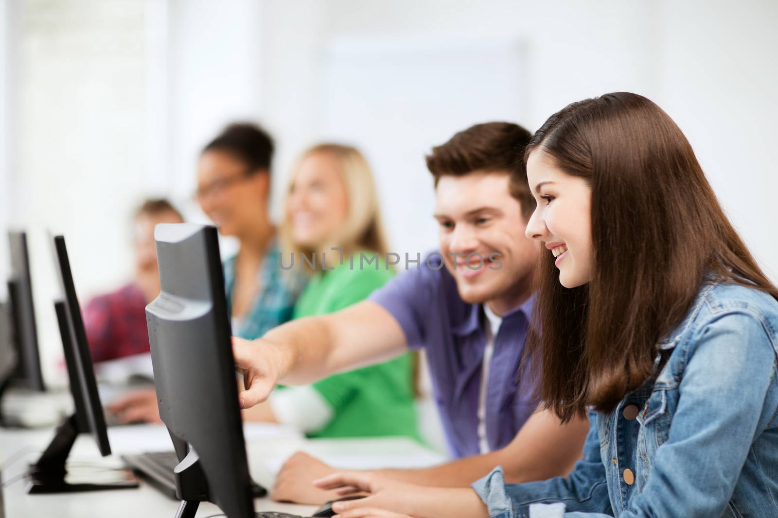 students with computers studying at school by dolgachov