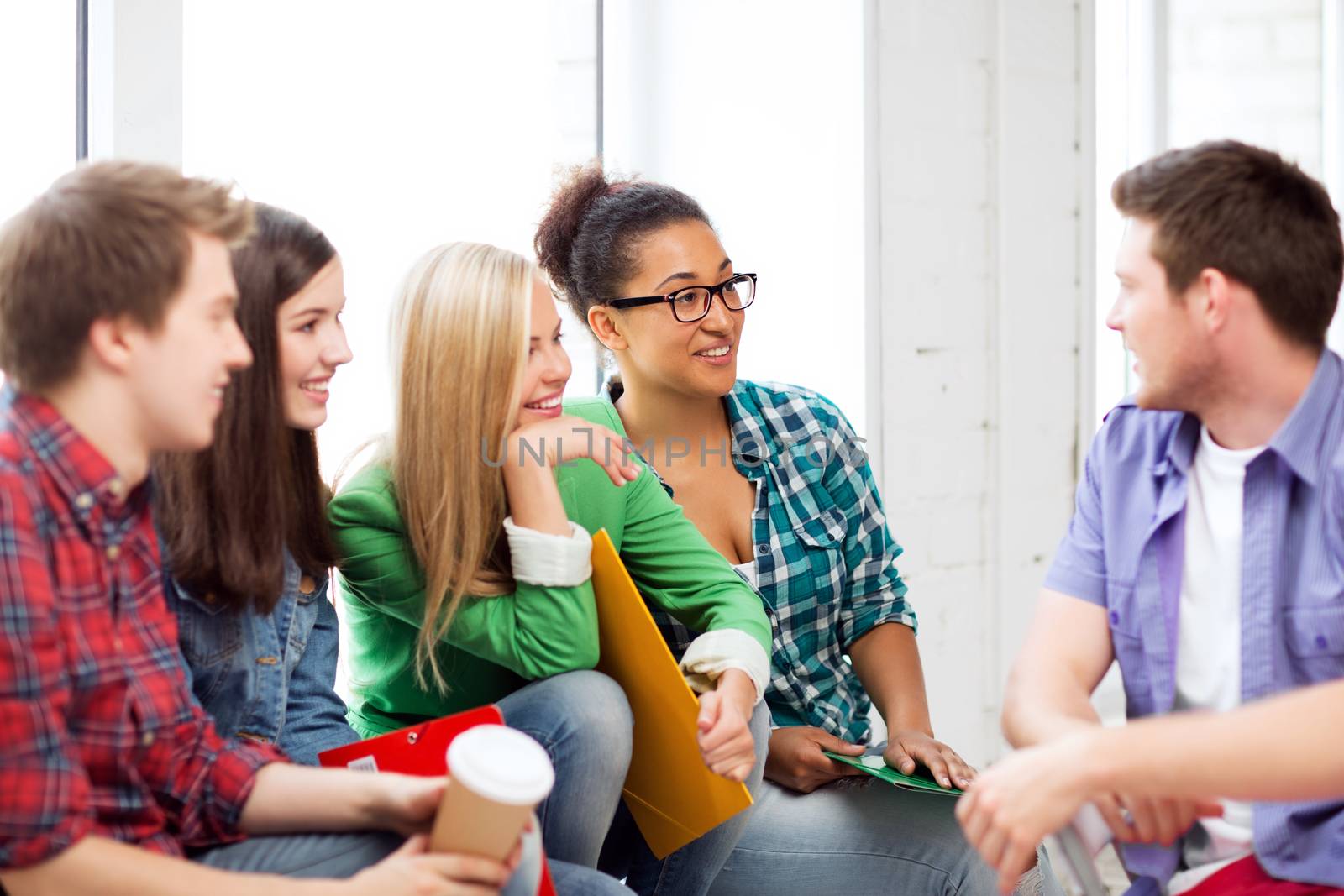 students communicating and laughing at school by dolgachov