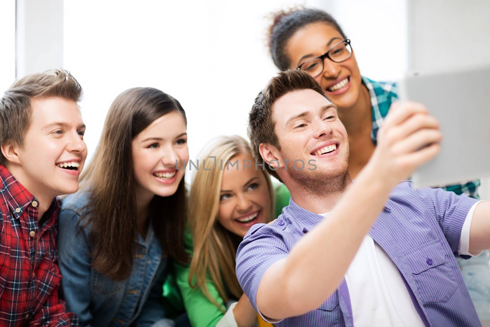 internet and technology concept - group of students making picture with tablet pc