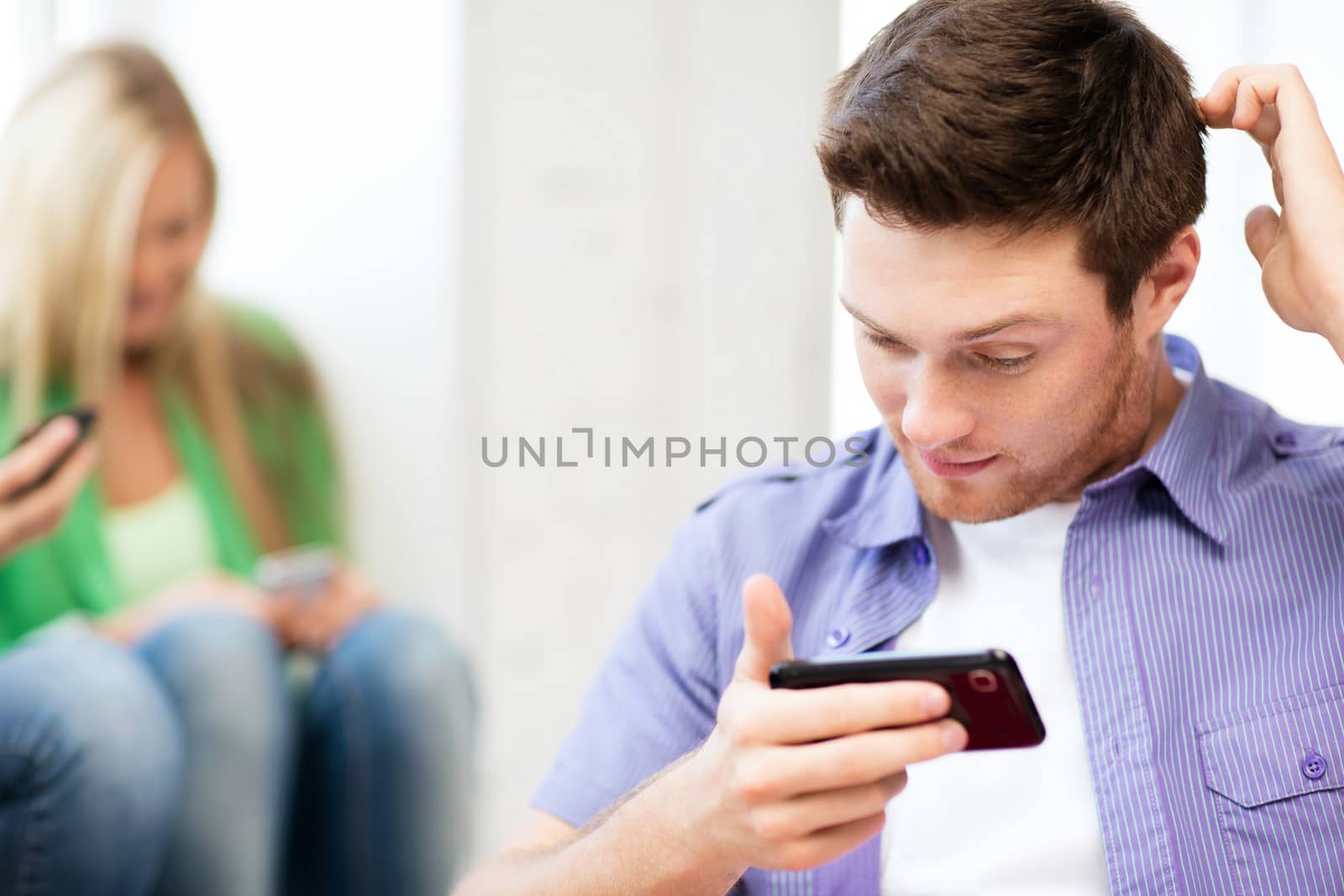 student looking at phone and writing something by dolgachov