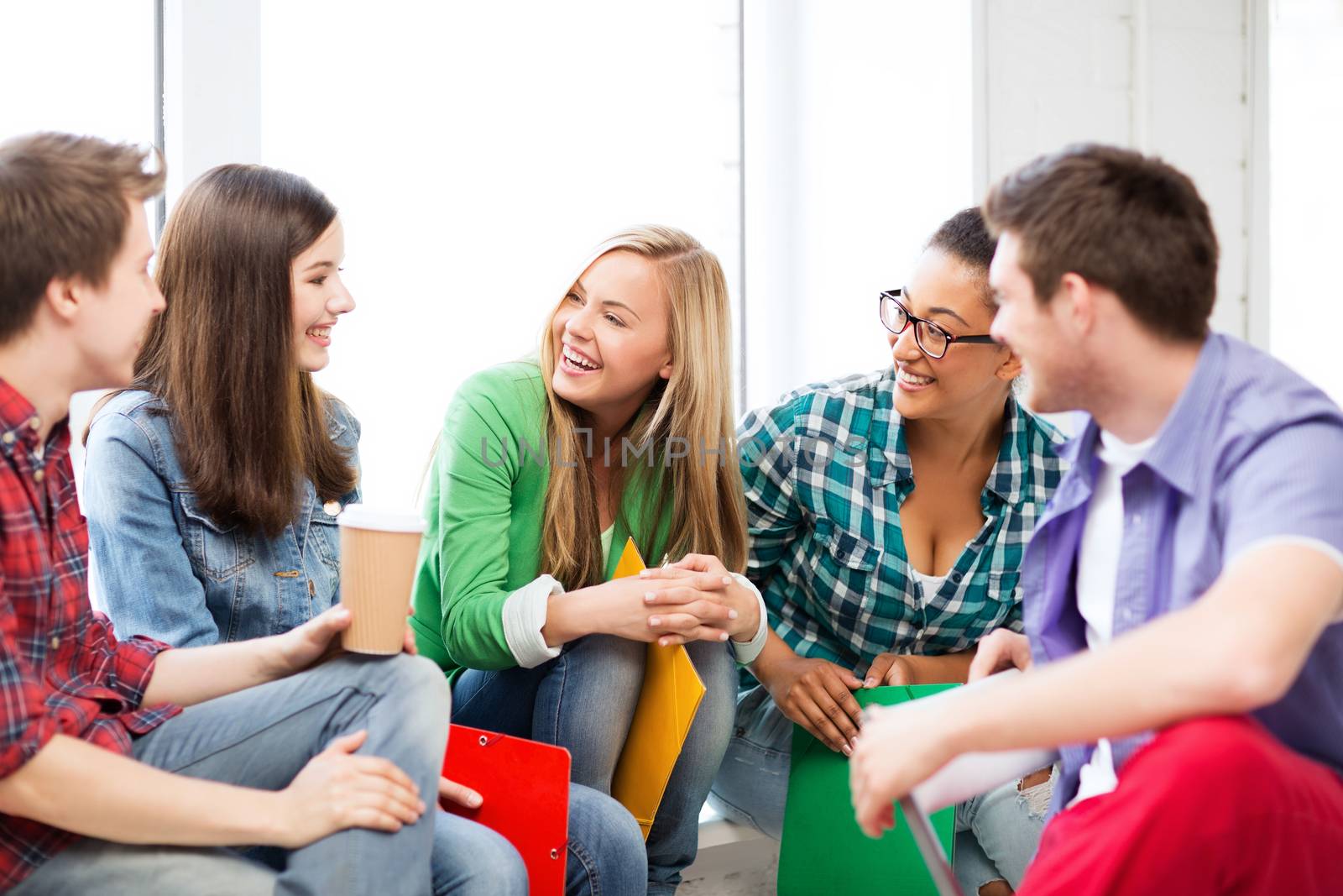 students communicating and laughing at school by dolgachov