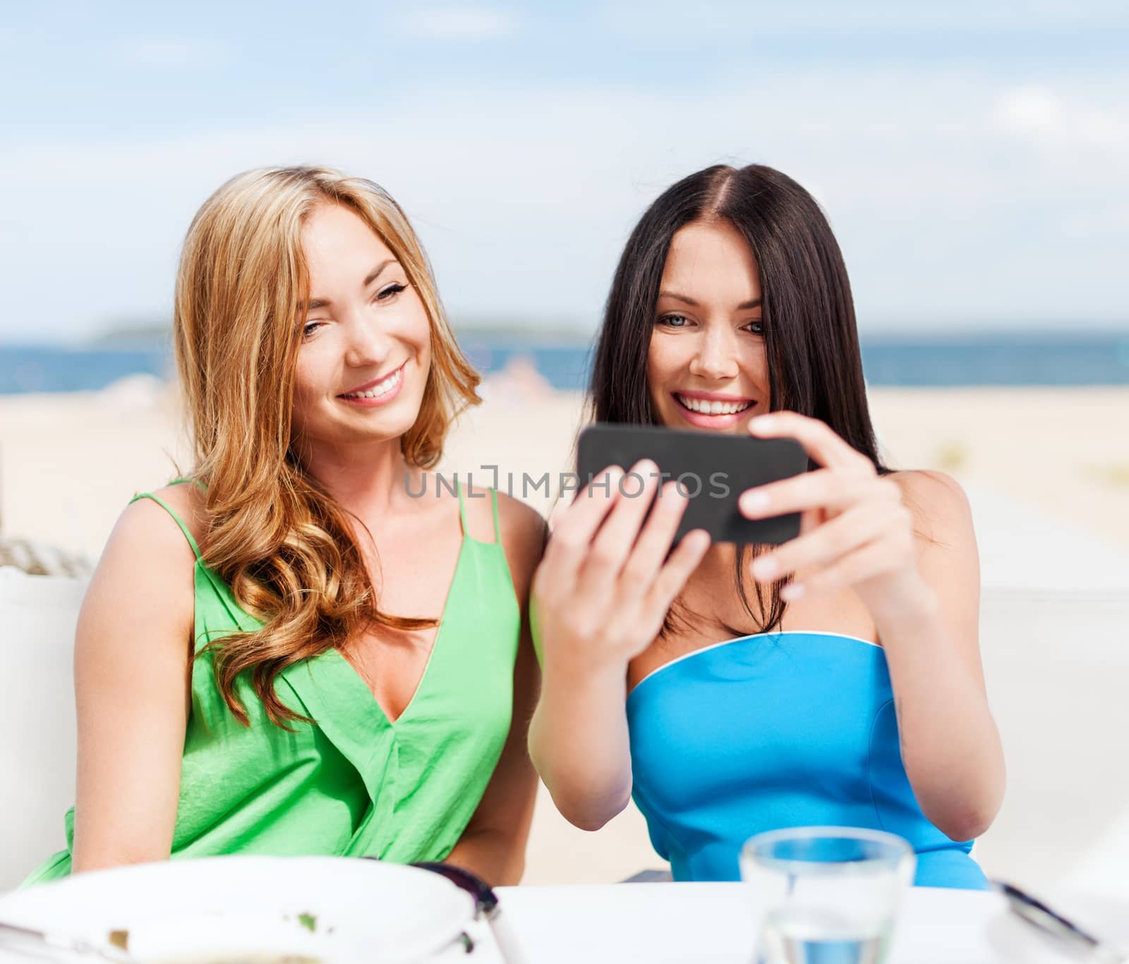 girls taking photo in cafe on the beach by dolgachov