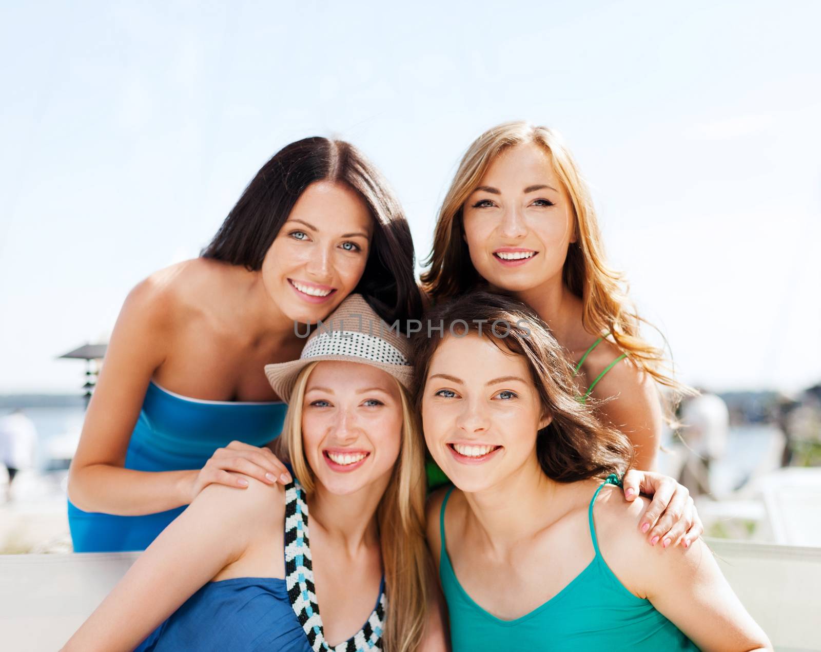 summer holidays and vacation - group of girls in cafe on the beach