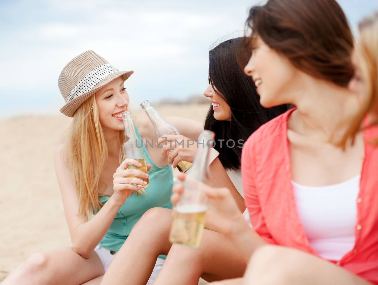 summer holidays and vacation concept - girls with drinks on the beach