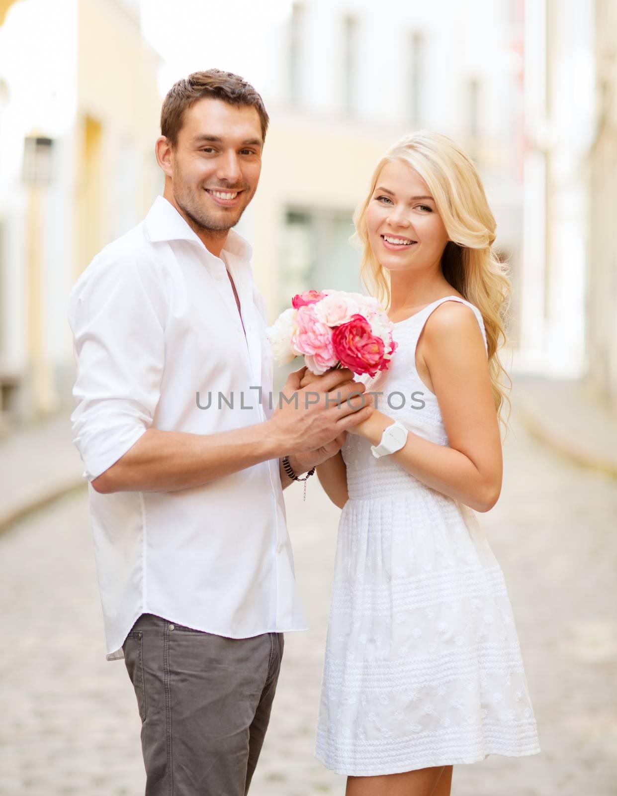 summer holidays and dating concept - couple with bouquet of flowers in the city