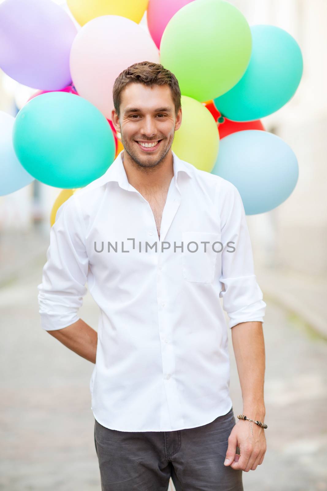 summer holidays, celebration and lifestyle concept - man with colorful balloons in the city