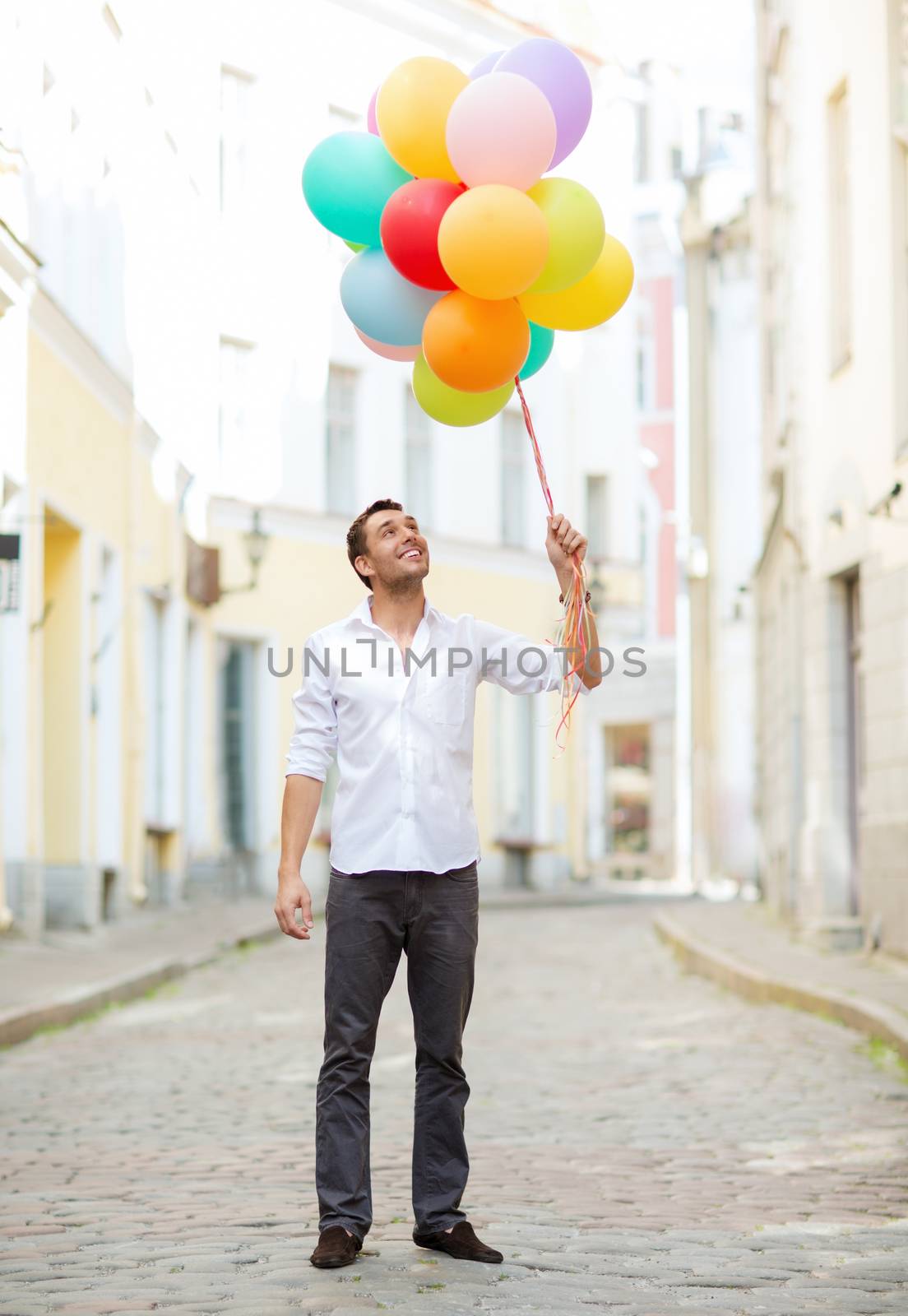 man with colorful balloons in the city by dolgachov