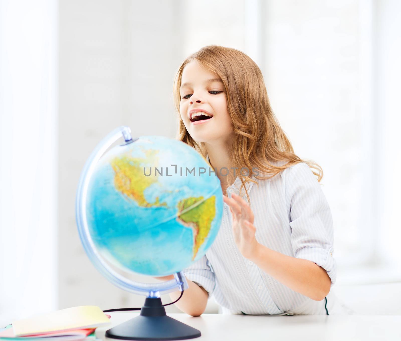 education and school concept - little student girl with globe at school