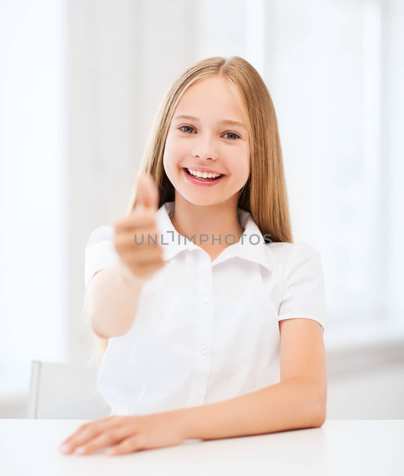 education and school concept - little student girl showing thumbs up at school
