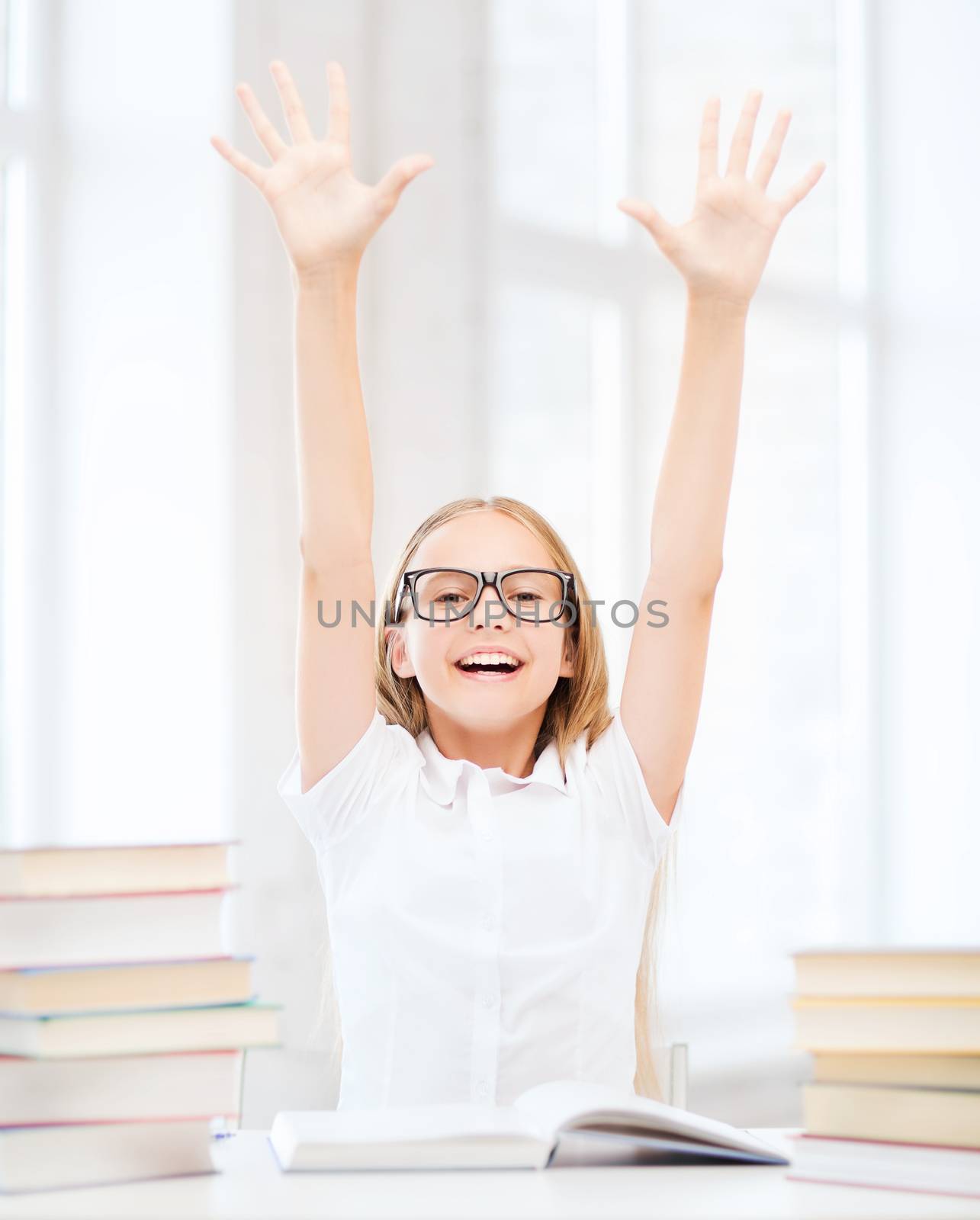 education and school concept - little student girl with books and hands up at school