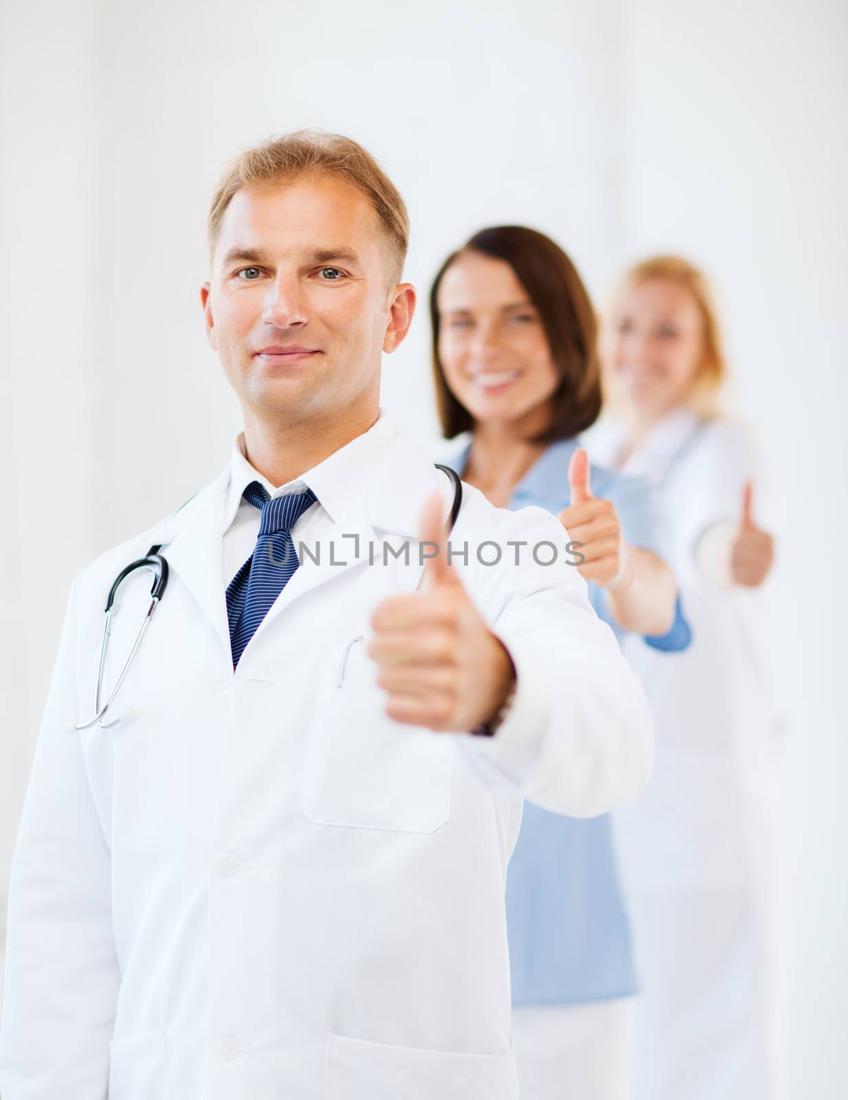 doctor with stethoscope and colleagues by dolgachov