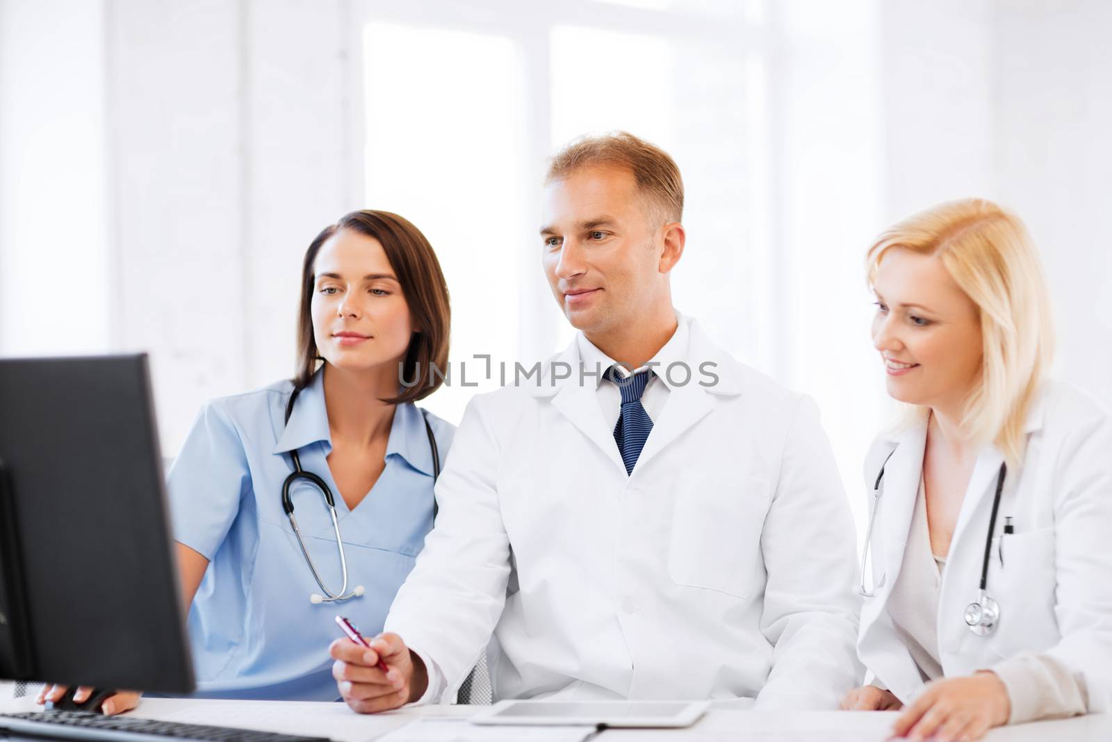 doctors looking at computer on meeting by dolgachov