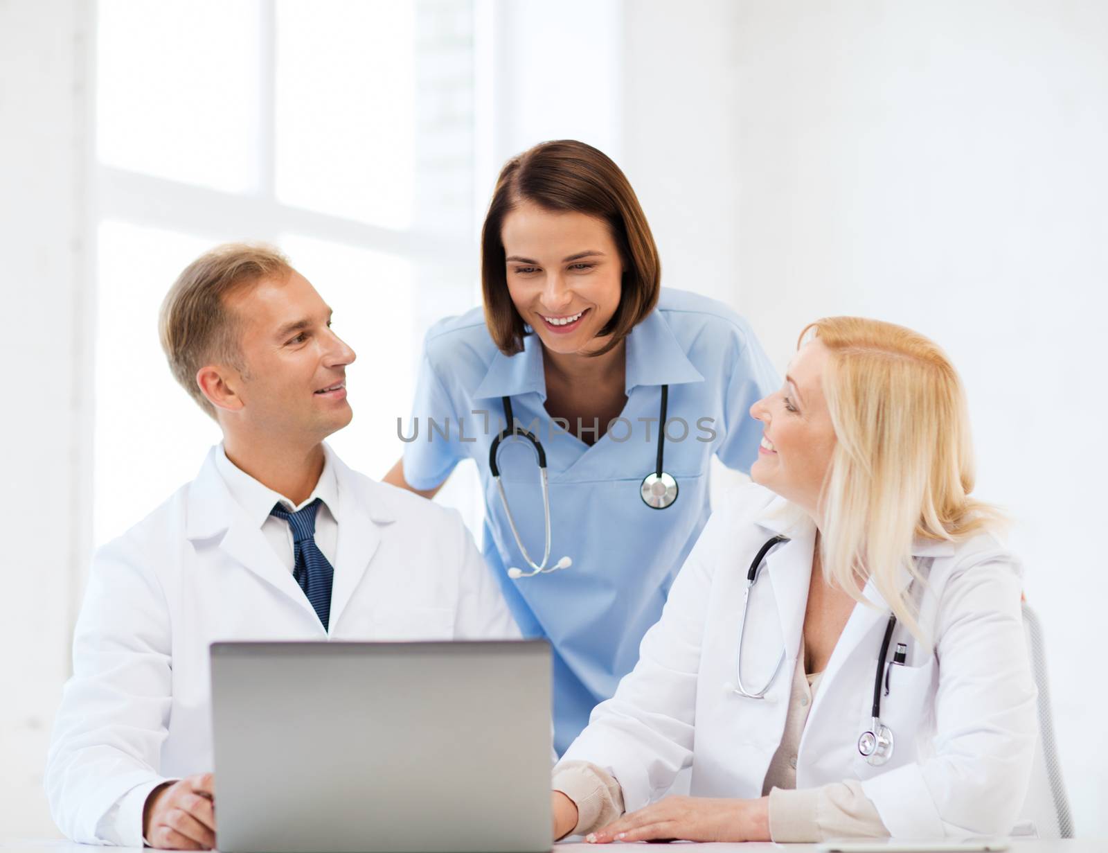 healthcare, medical and technology concept - group of doctors looking at laptop