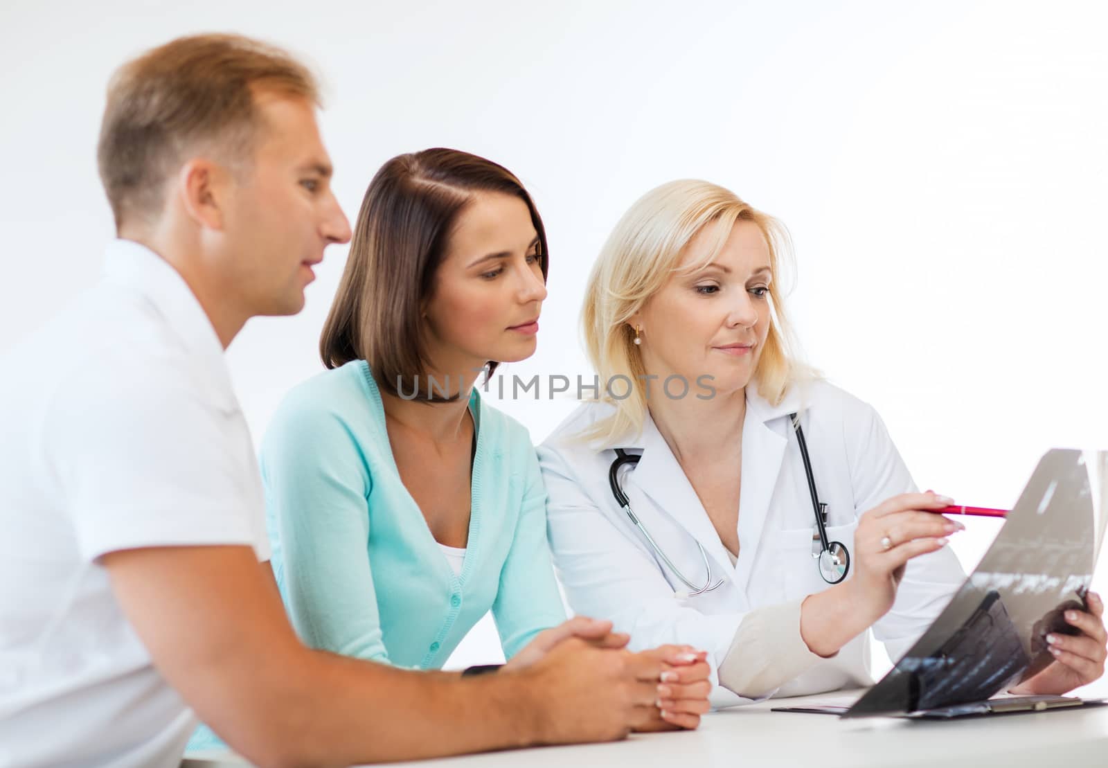 doctor with patients looking at x-ray by dolgachov