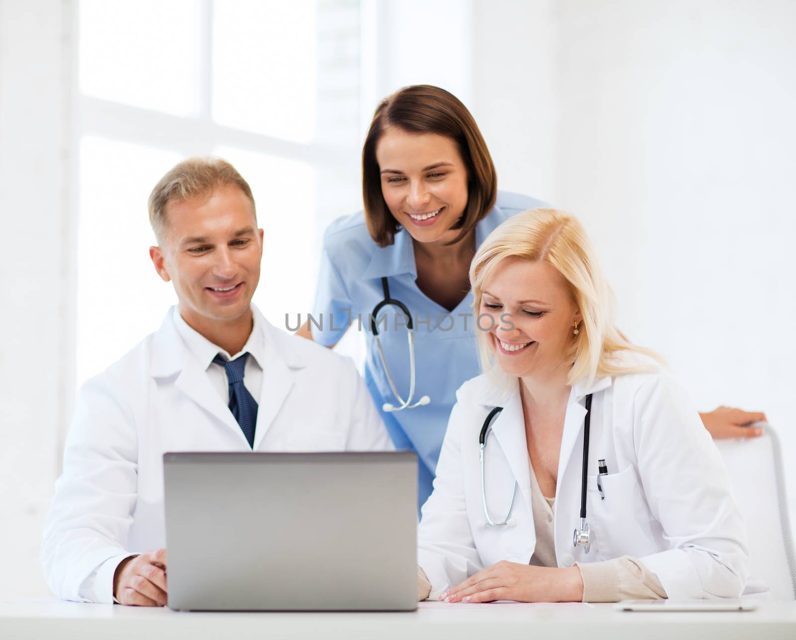 healthcare, medical and technology concept - group of doctors looking at laptop