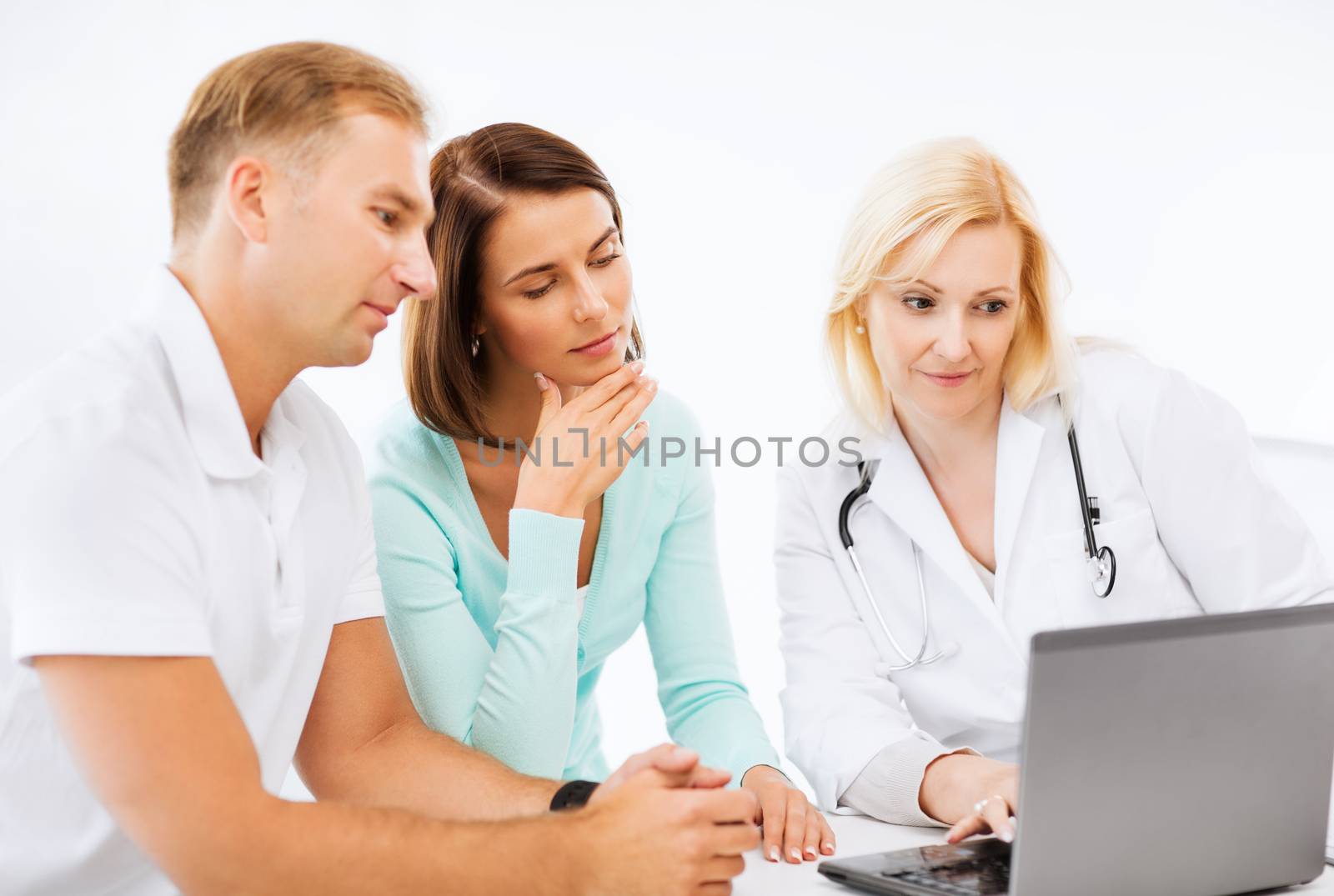 doctor with patients looking at laptop by dolgachov