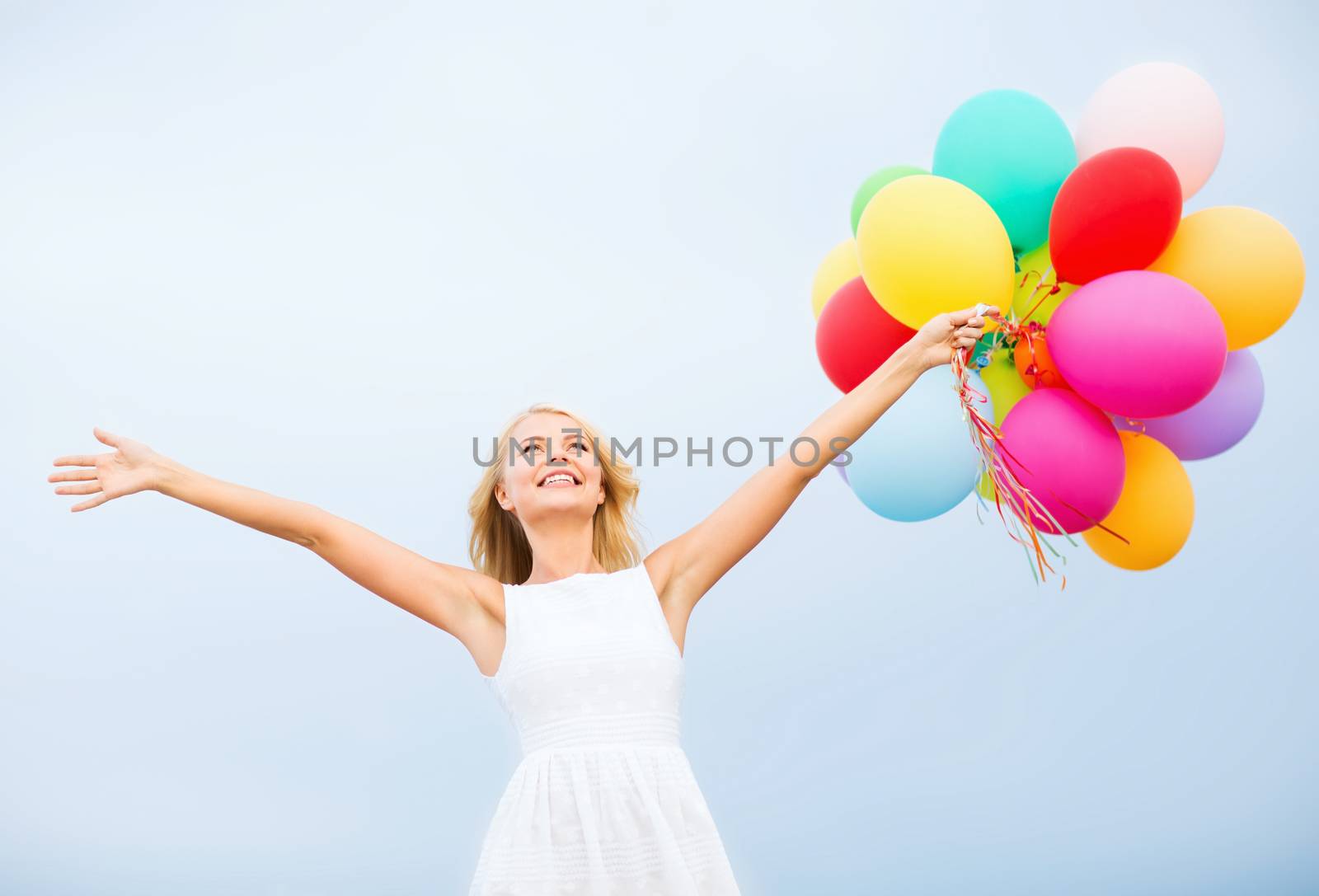 woman with colorful balloons outside by dolgachov